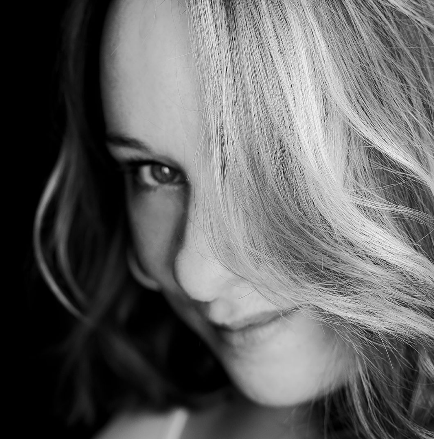 Black and white artistic portrait series showing close-up views of blonde hair and partial facial features in moody lighting.