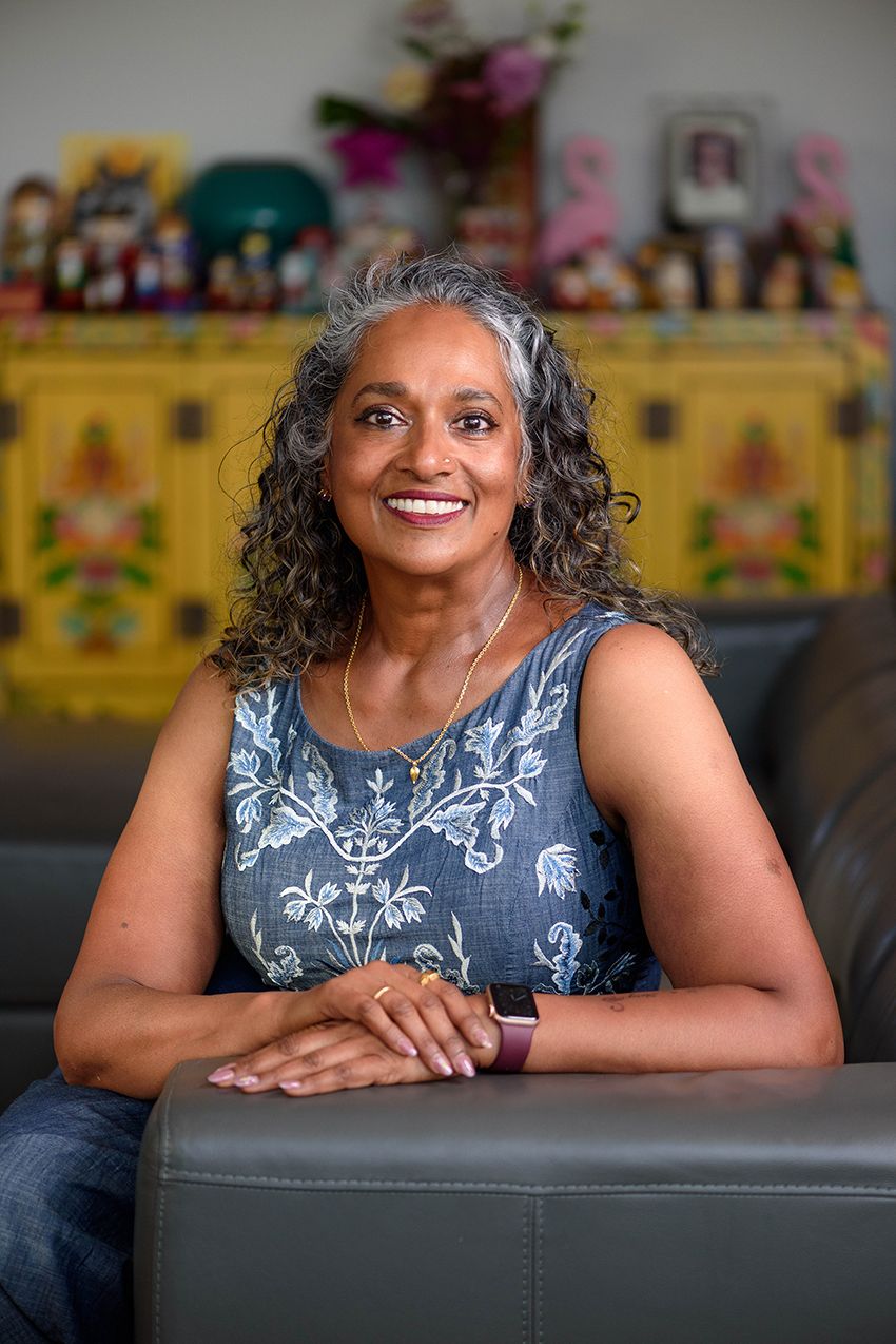 Business portrait of a mature woman with curls on a couch with colourful things in background - Kelly Chapman Photographer Perth