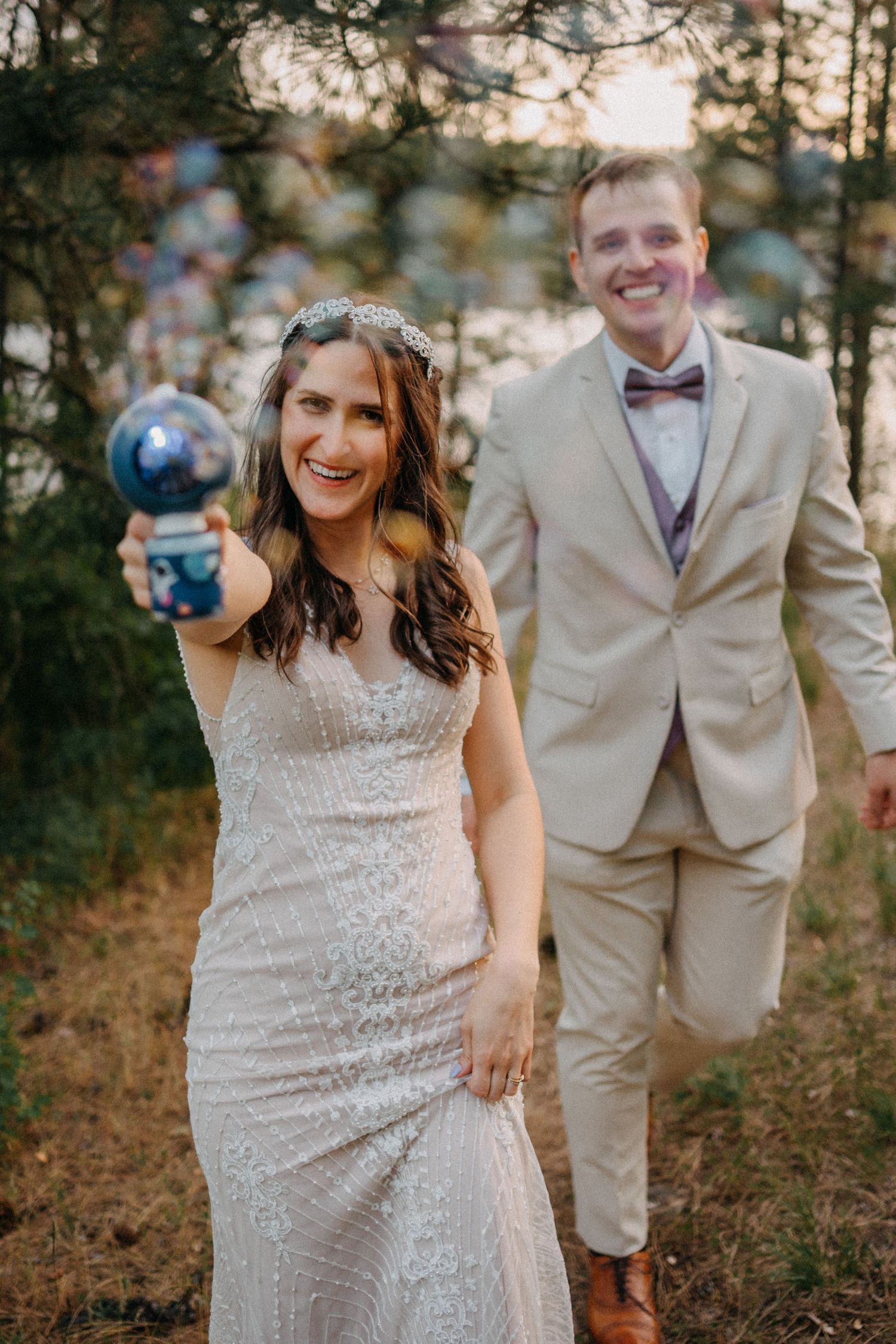 A couple shares playful and candid moments in a forest setting during their wedding photoshoot.