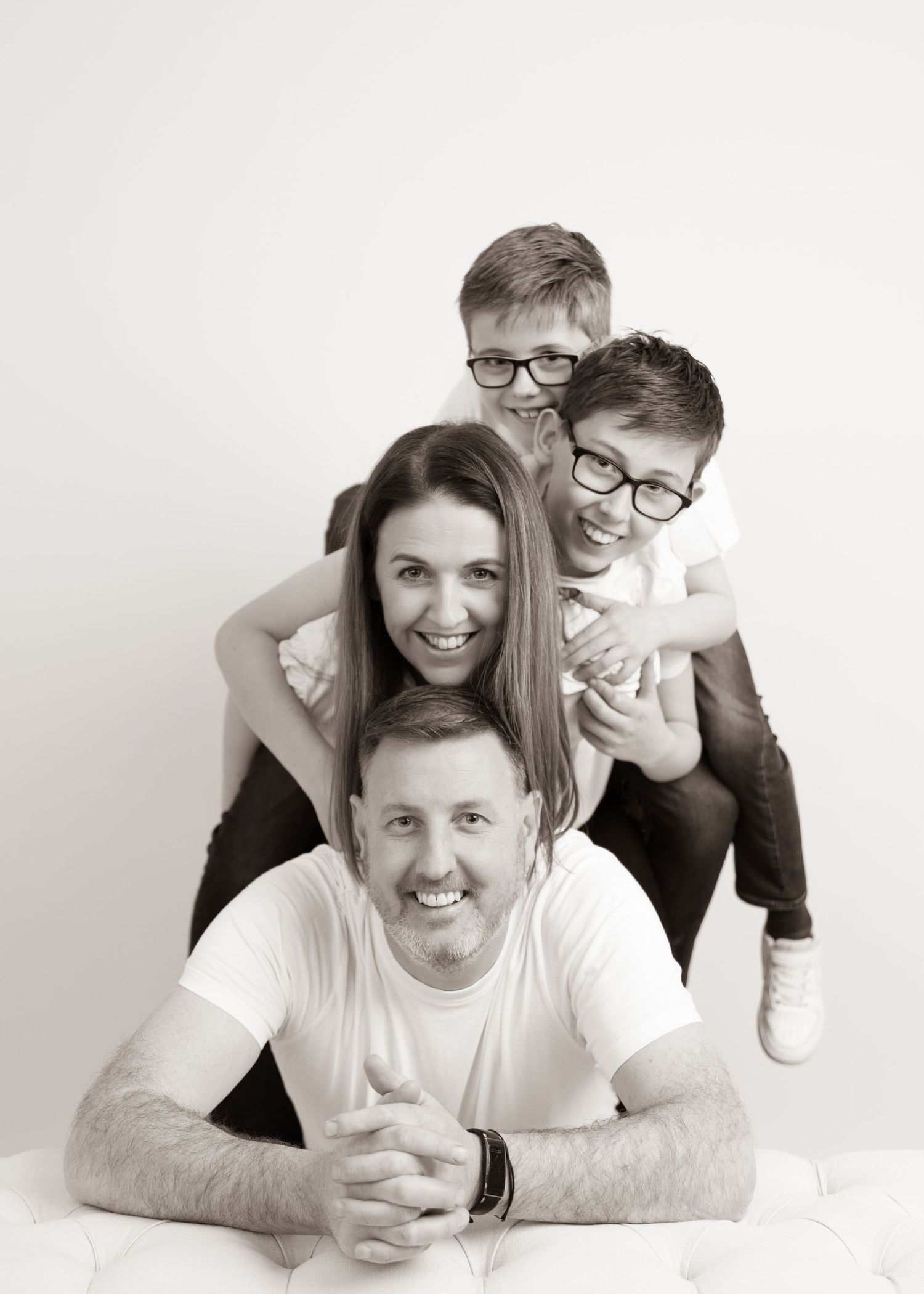 Family portrait series showing playful poses against white background in casual attire.