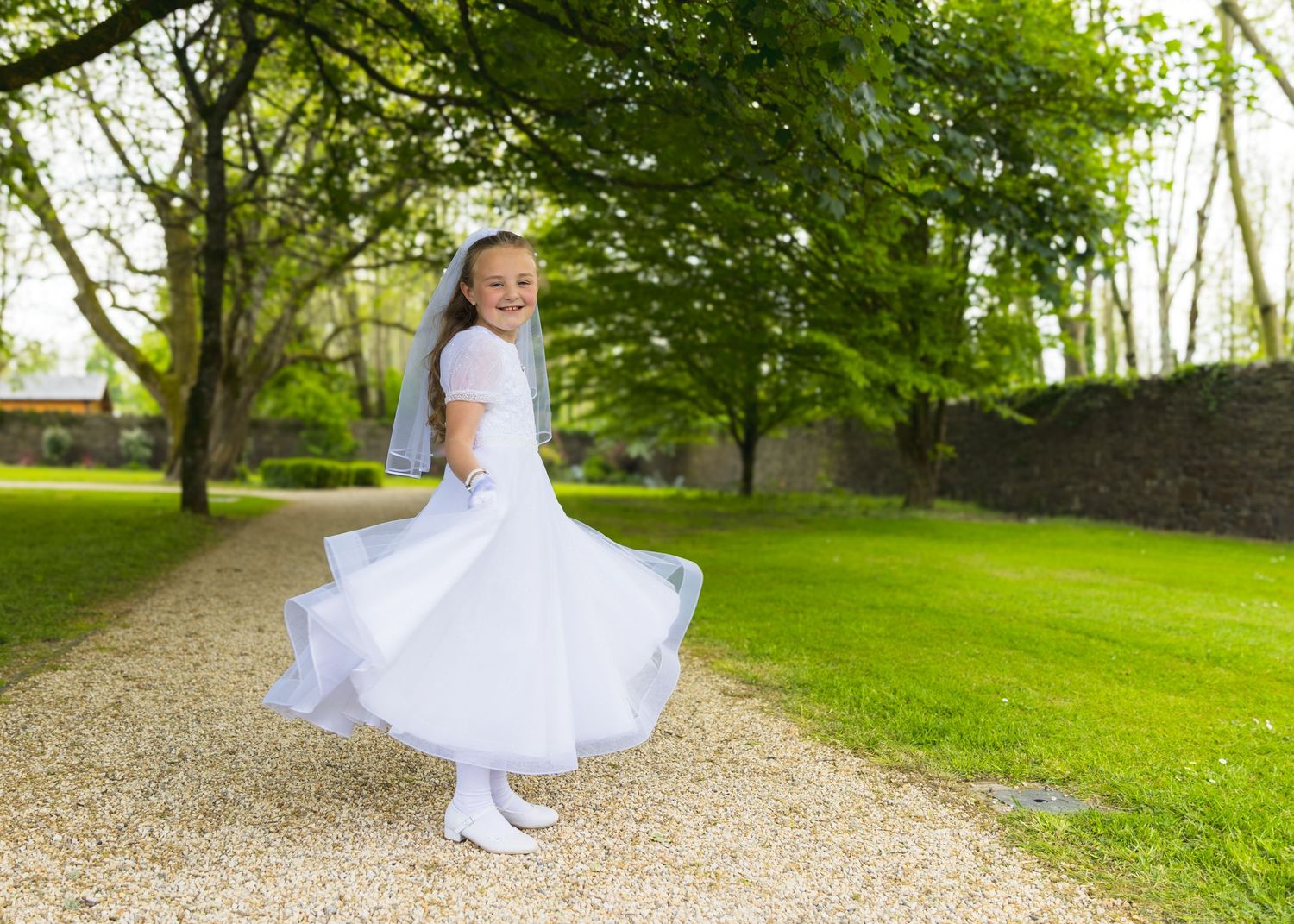 A sequence of photos showing a white dress twirling in a lush green garden setting.