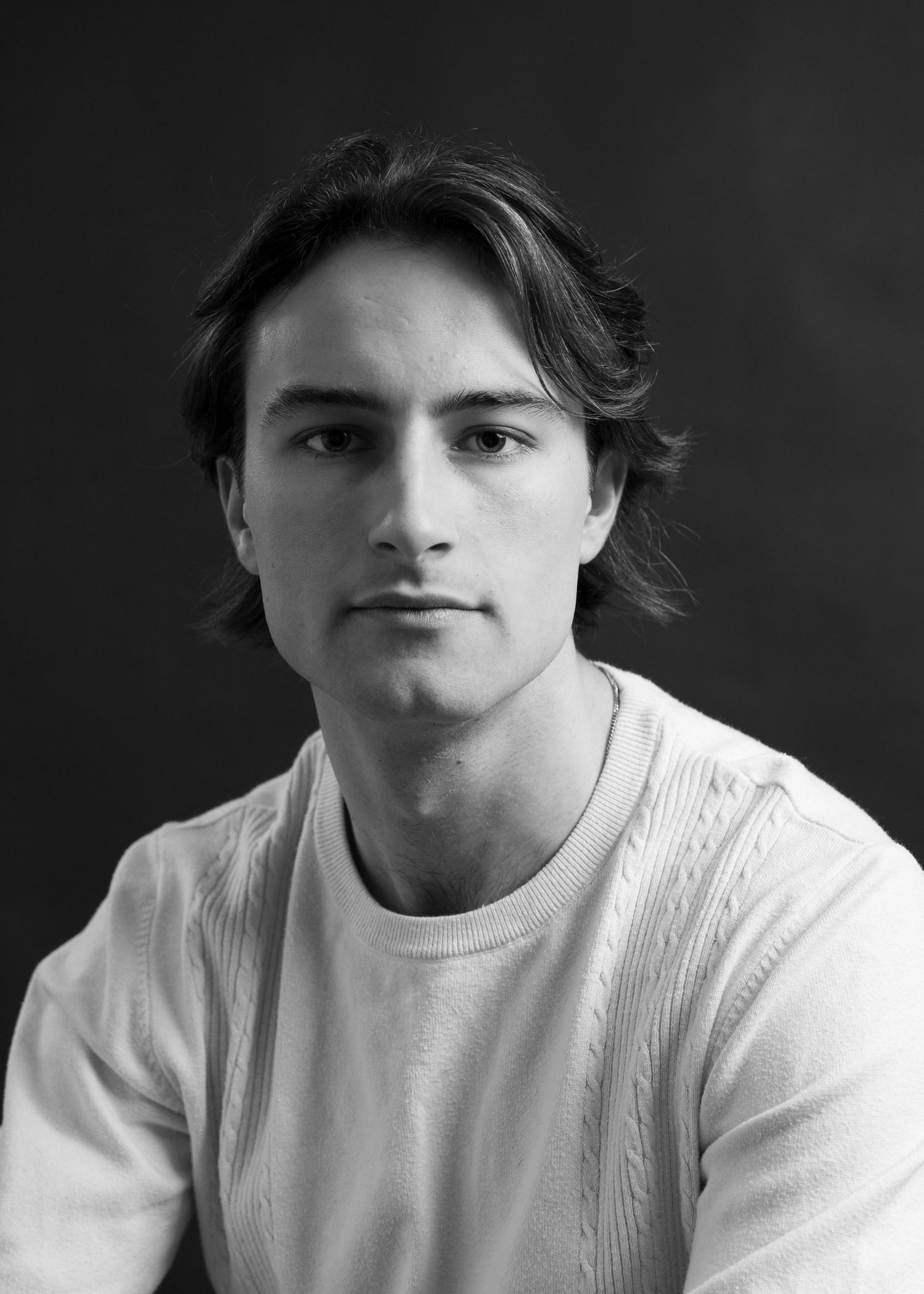 Series of black and white portraits in a white cable knit sweater.