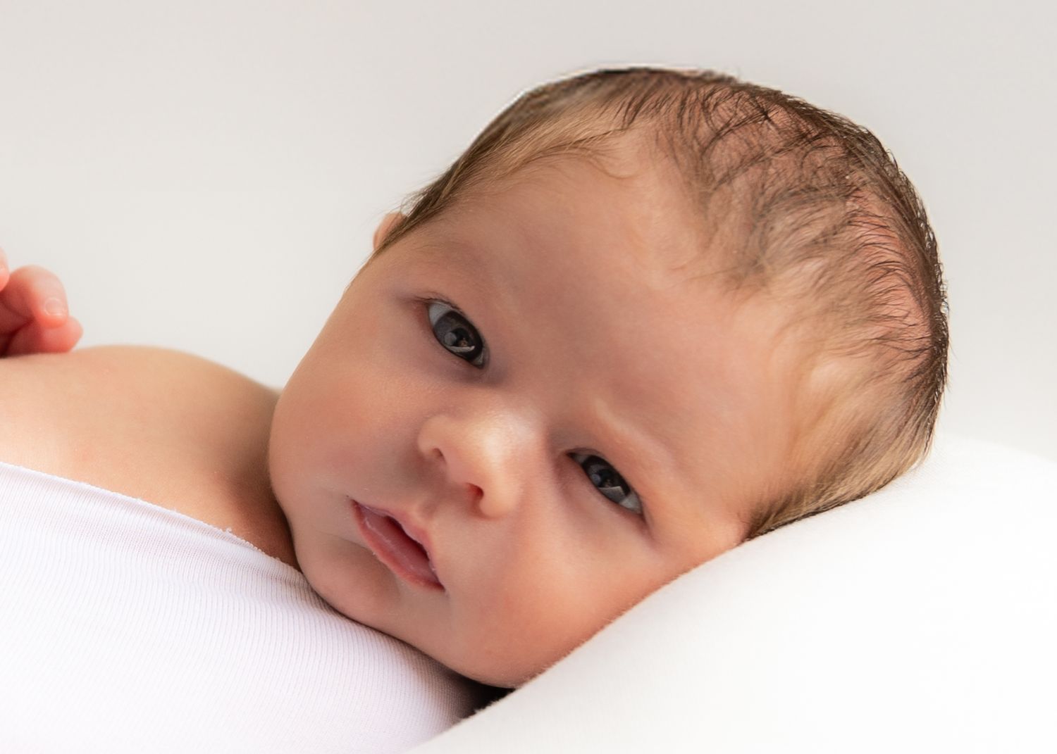 Close-up profile view of baby's face against white background.