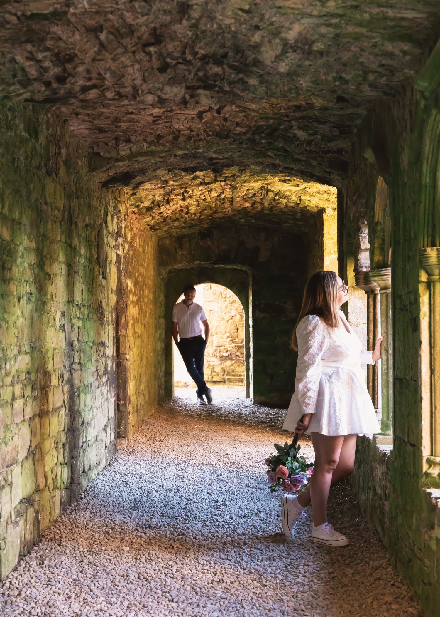 Stone tunnel corridor with natural lighting streaming through arched openings.
