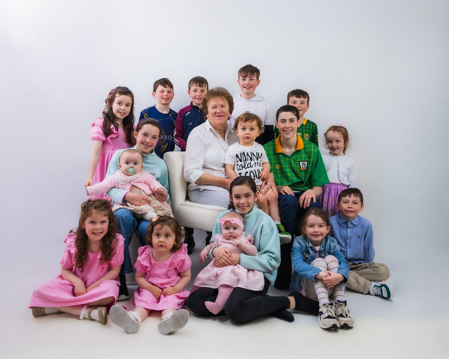 A family group photo session against a white studio backdrop.
