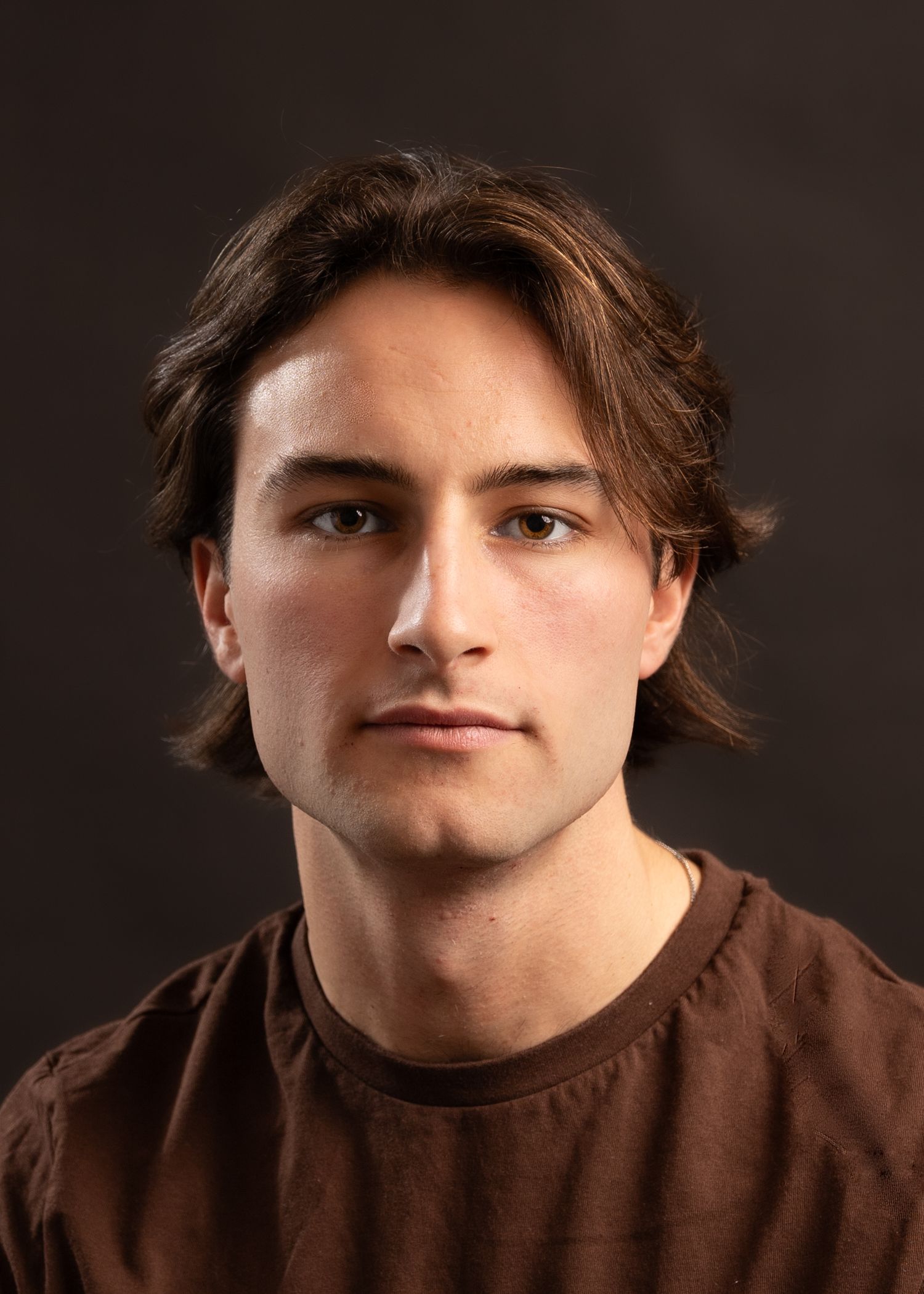 Close-up portrait series in a brown shirt showing various expressions.