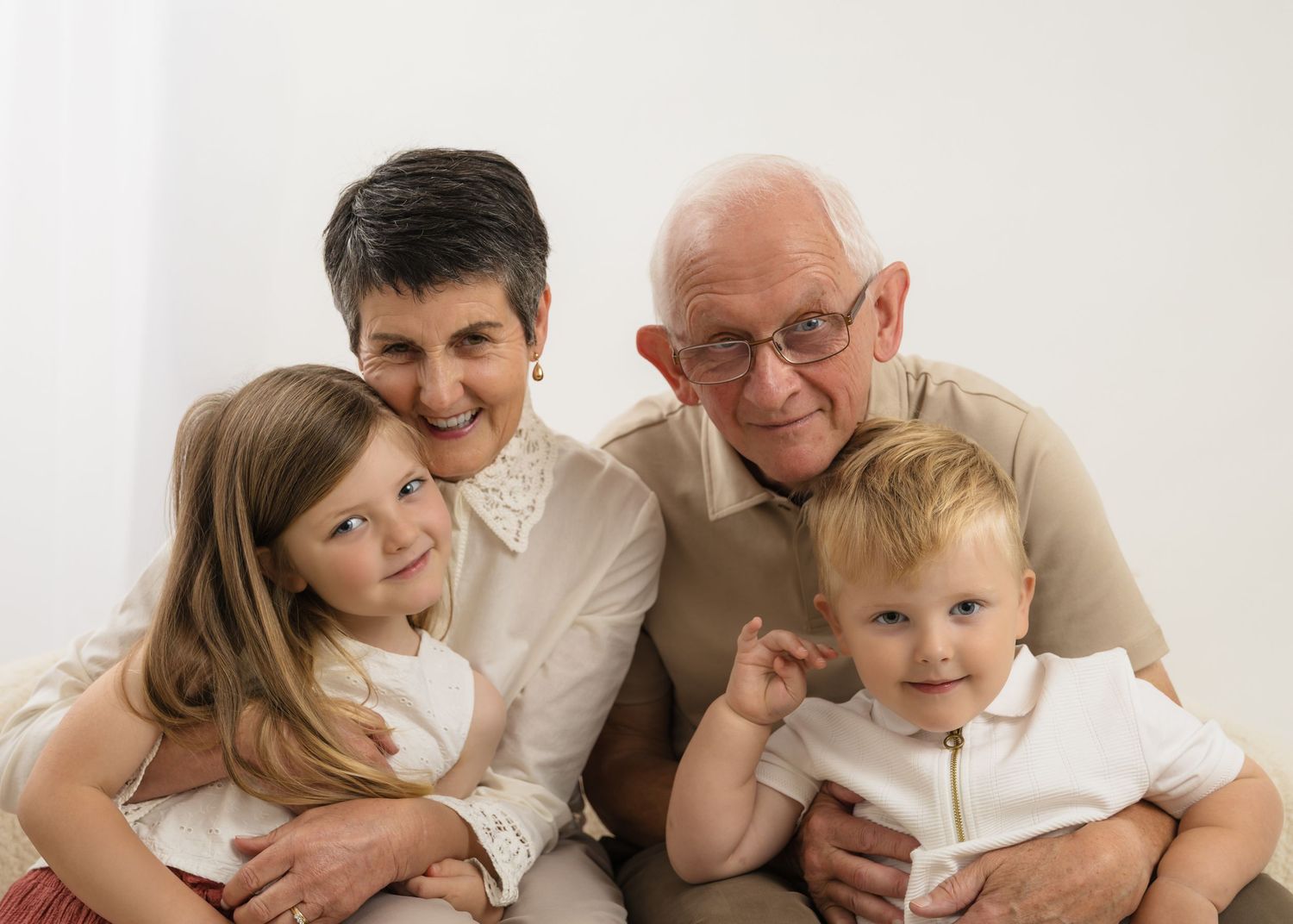 Family members of different generations share a warm moment together in a studio setting.