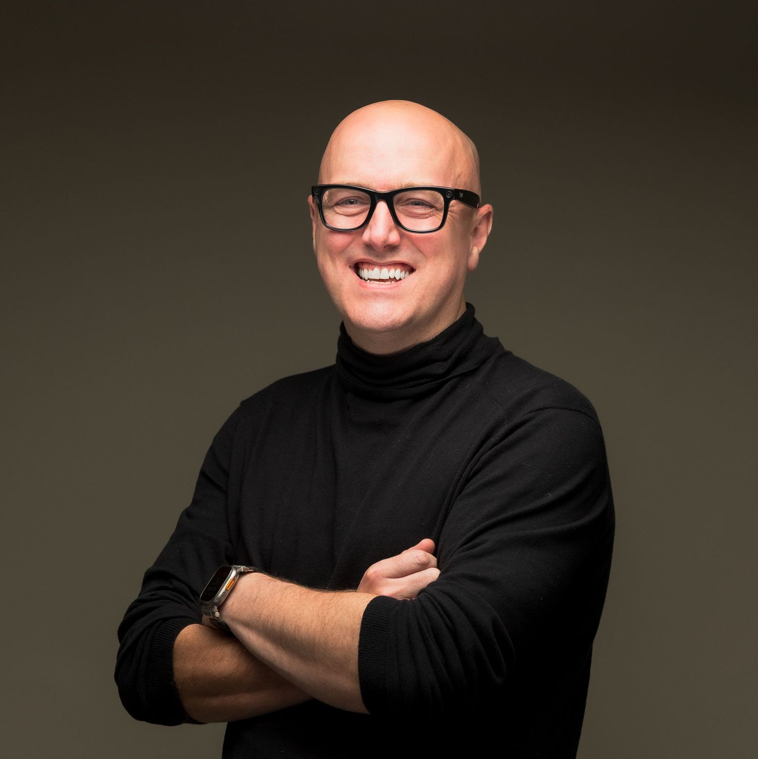 Portrait of someone in a black turtleneck and glasses against a dark background, shown in multiple poses.