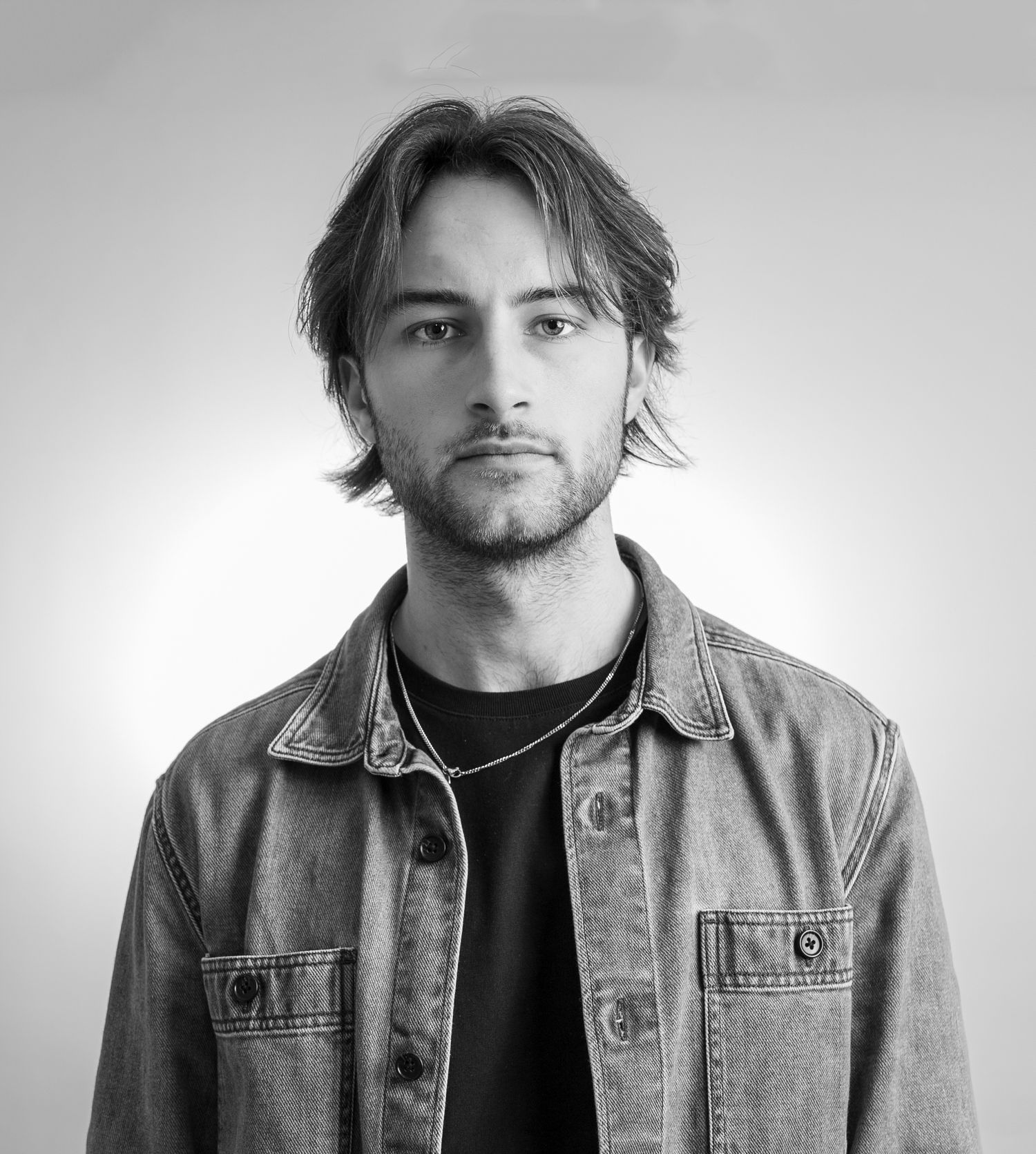 Black and white portrait series showing different angles in denim jacket and dark shirt.