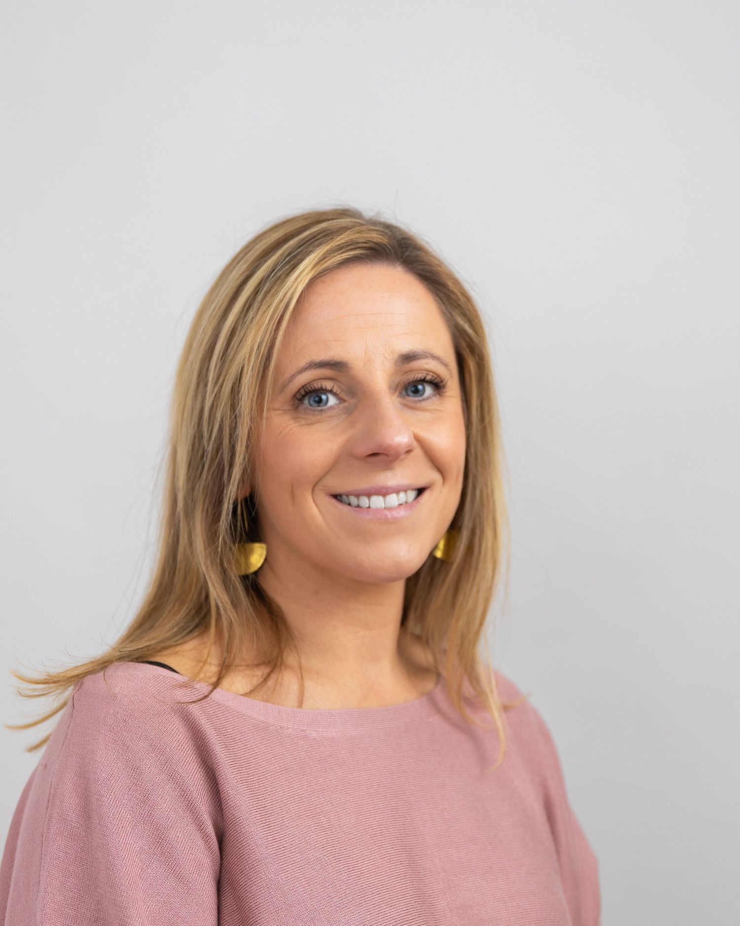 Portrait series showing different expressions while wearing pink top against white background.