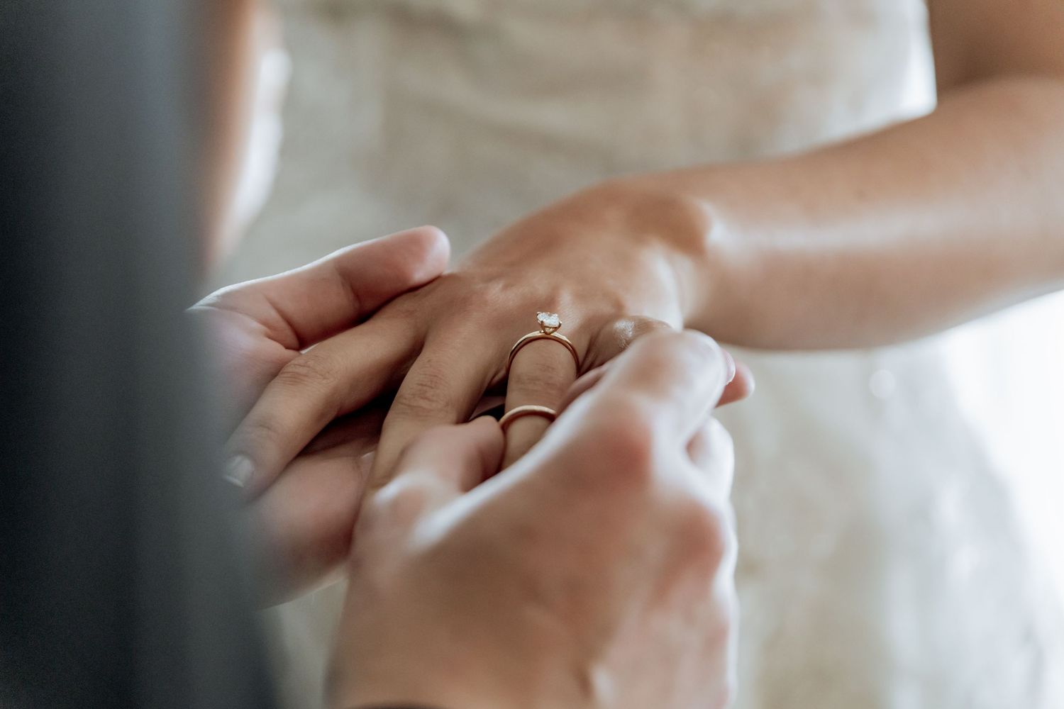 Hands exchanging rings during a wedding ceremony closeup shot showing traditional gold bands.