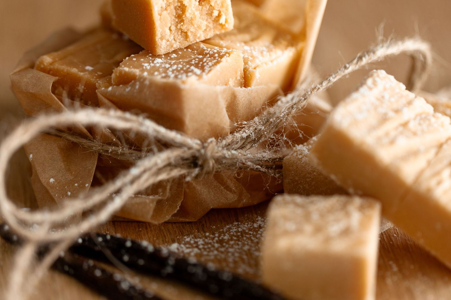 Homemade fudge pieces tied with rustic twine string on parchment paper in warm lighting.
