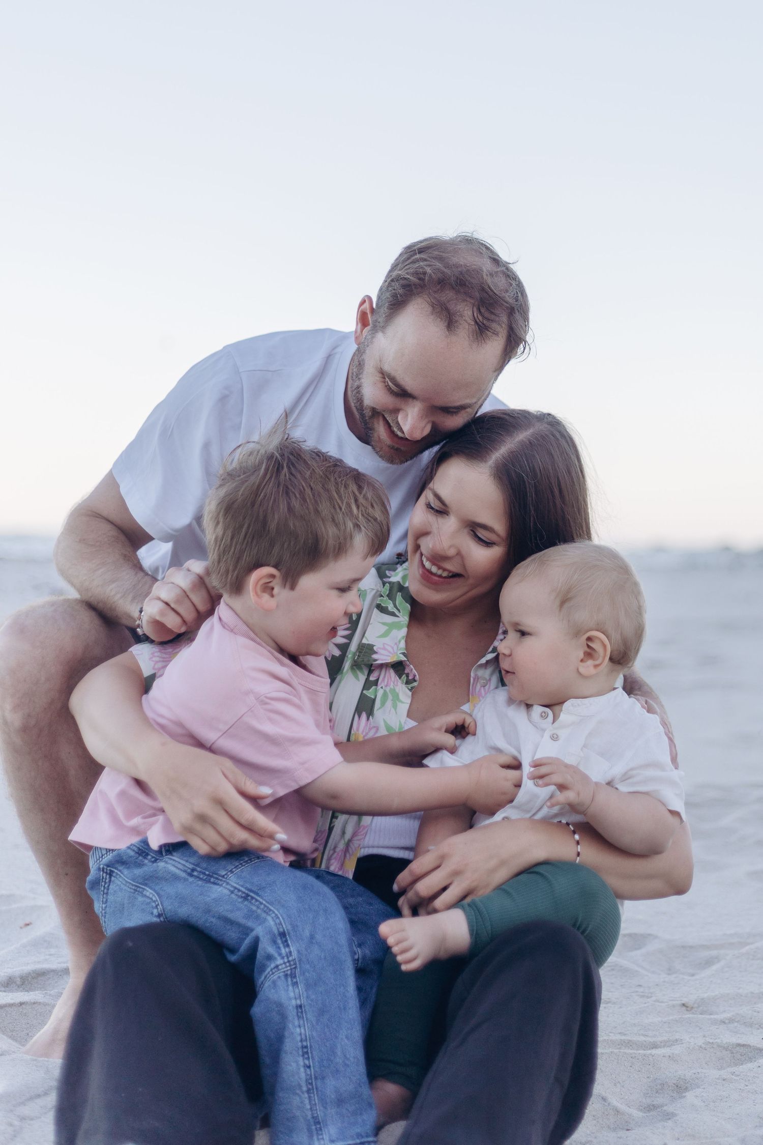 Happy family sharing a joyful moment together on the beach at sunset.