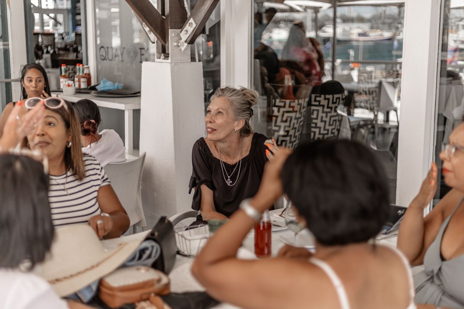 People gathered around a table during a casual dining event, sharing laughter and conversation.