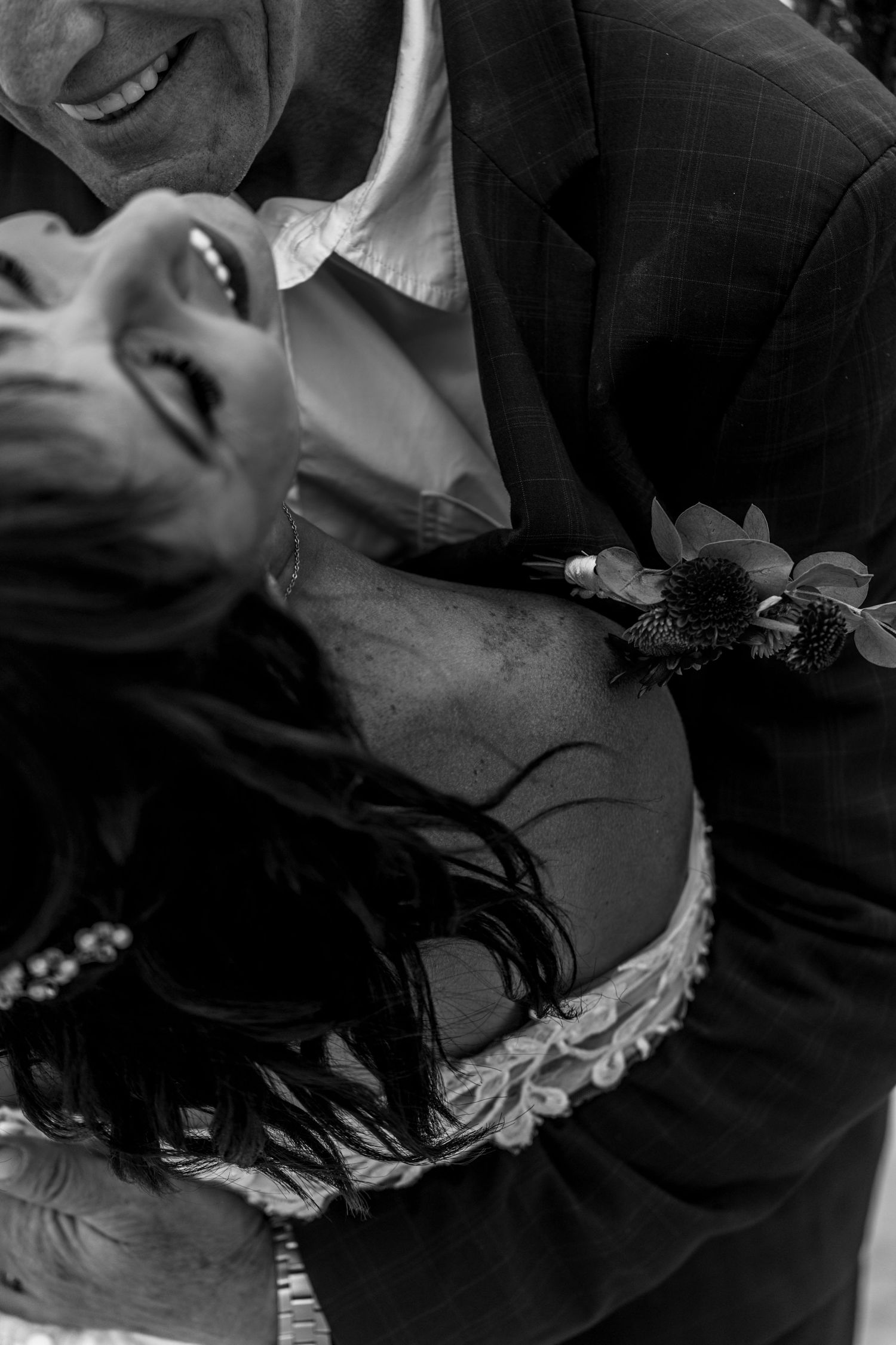 Black and white gothic wedding scene showing a couple kissing in dramatic lighting during their romantic ceremony.