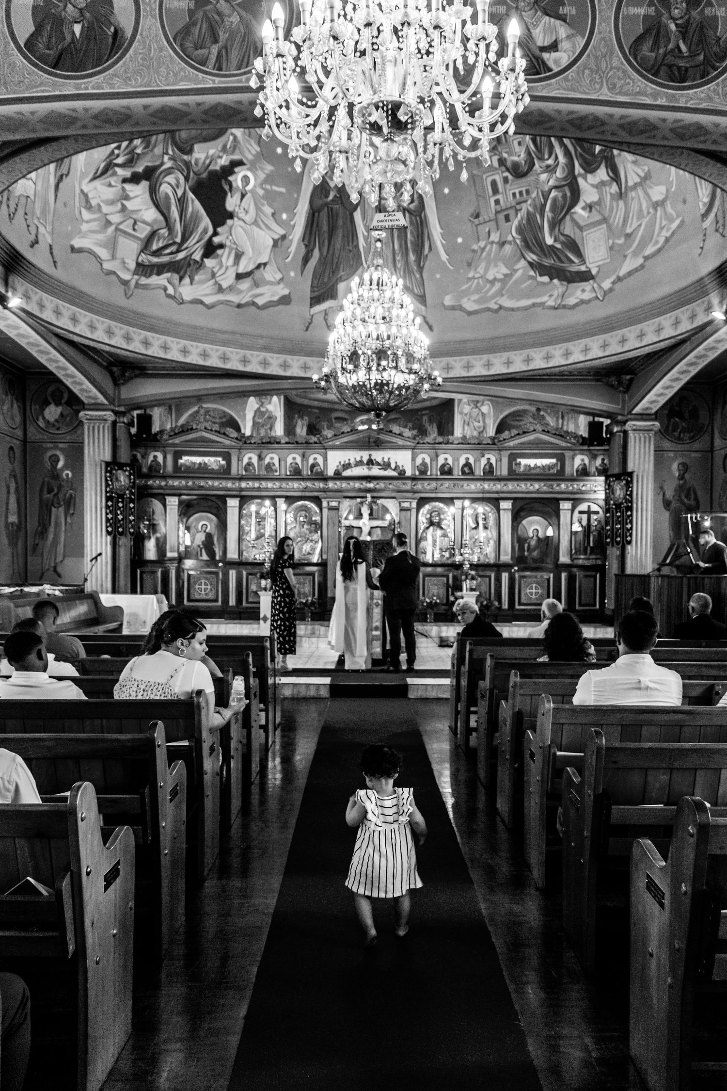 Elegant black and white panoramic view of a grand ballroom with ornate chandeliers and classical murals on the ceiling.