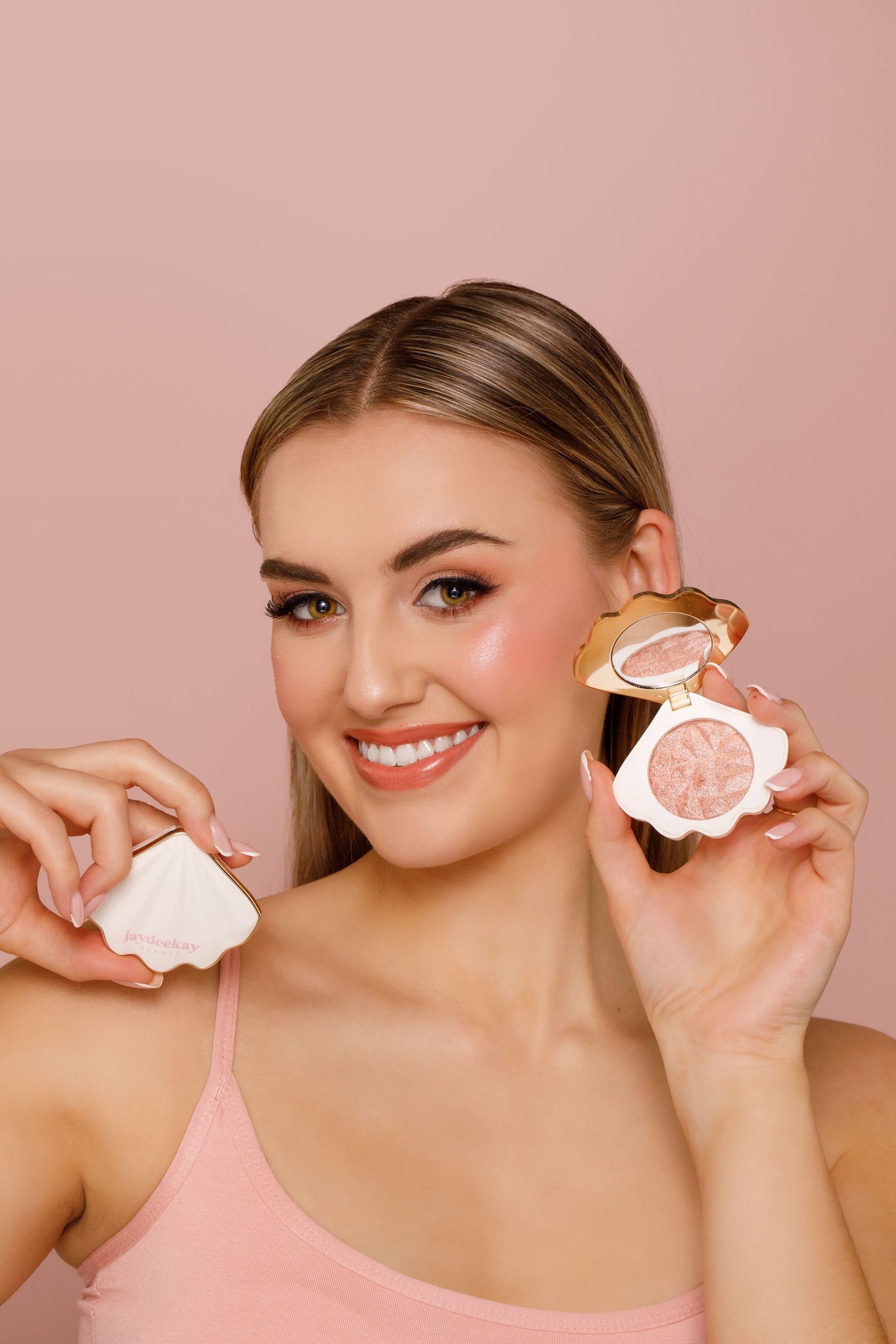 A series of photos showing someone holding frosted sugar cookies against a pink background.