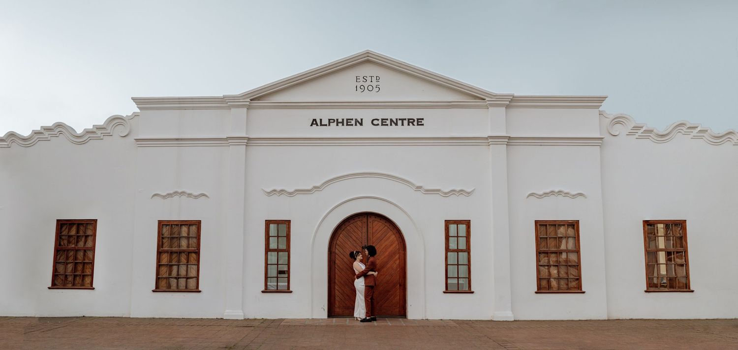 A white colonial-style building with arched doorway and windows serves as an Alackal Centre in a minimalist setting.