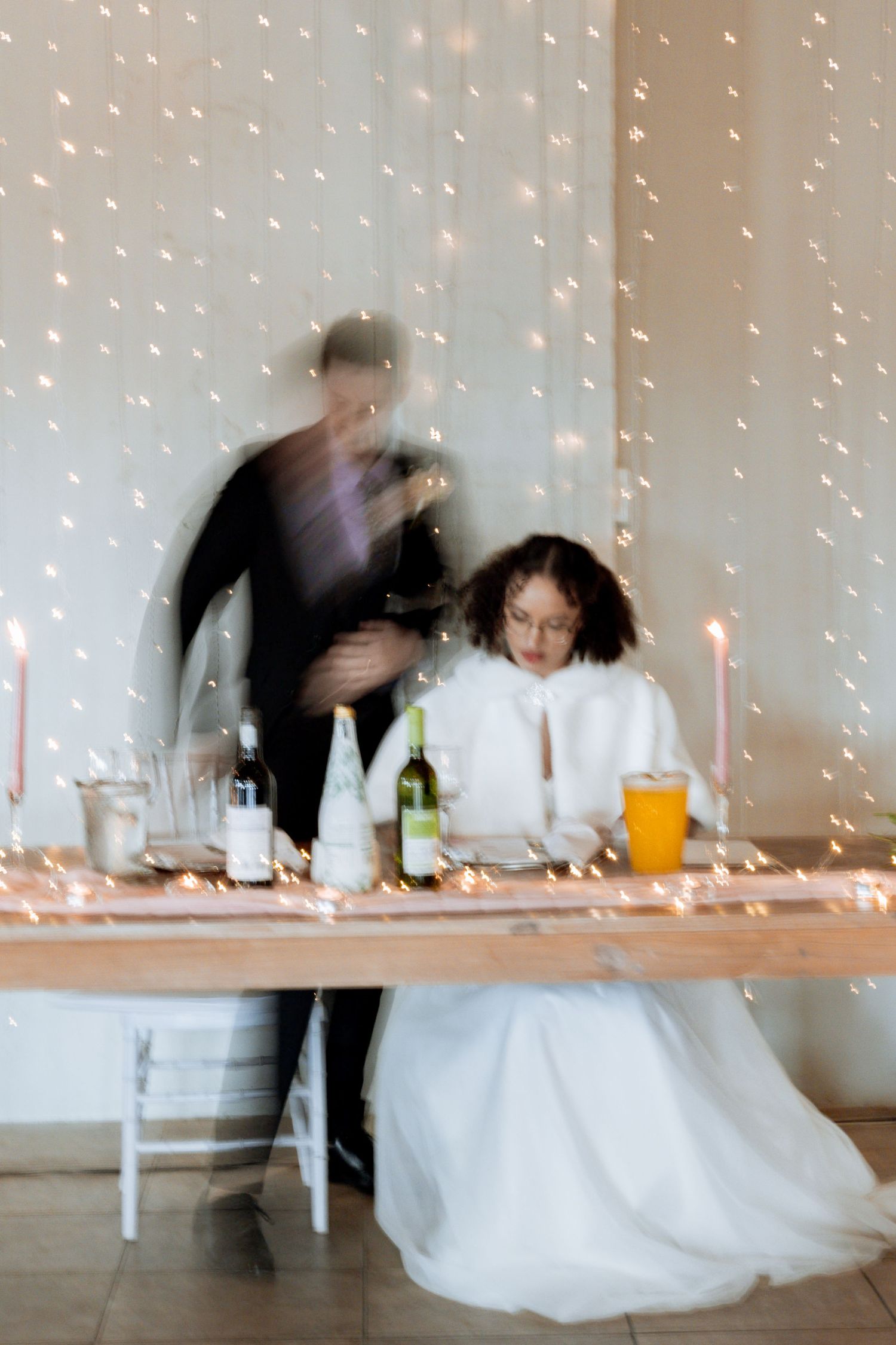 Time-lapse sequence shows guests mingling at reception tables with twinkling string lights creating an ethereal atmosphere.