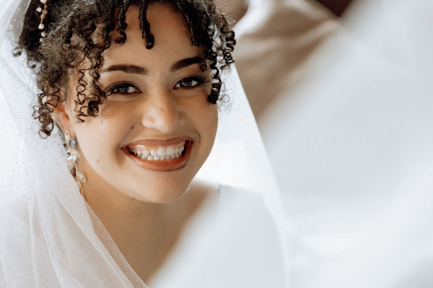 Four images merged horizontally showing a smiling individual in a white veil and wedding attire.