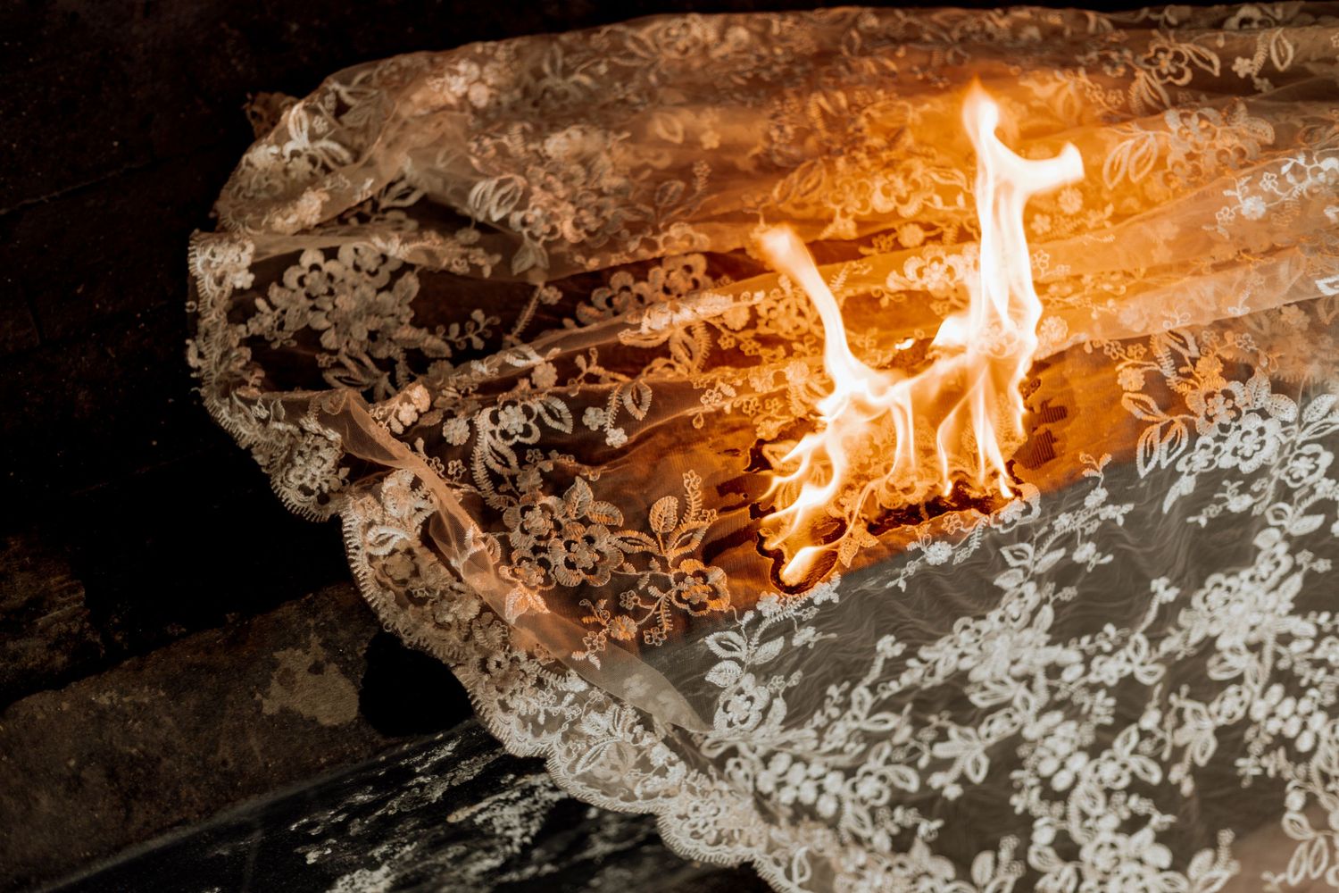Flames dance across molten metal in an industrial furnace creating a dramatic orange glow against dark surroundings.