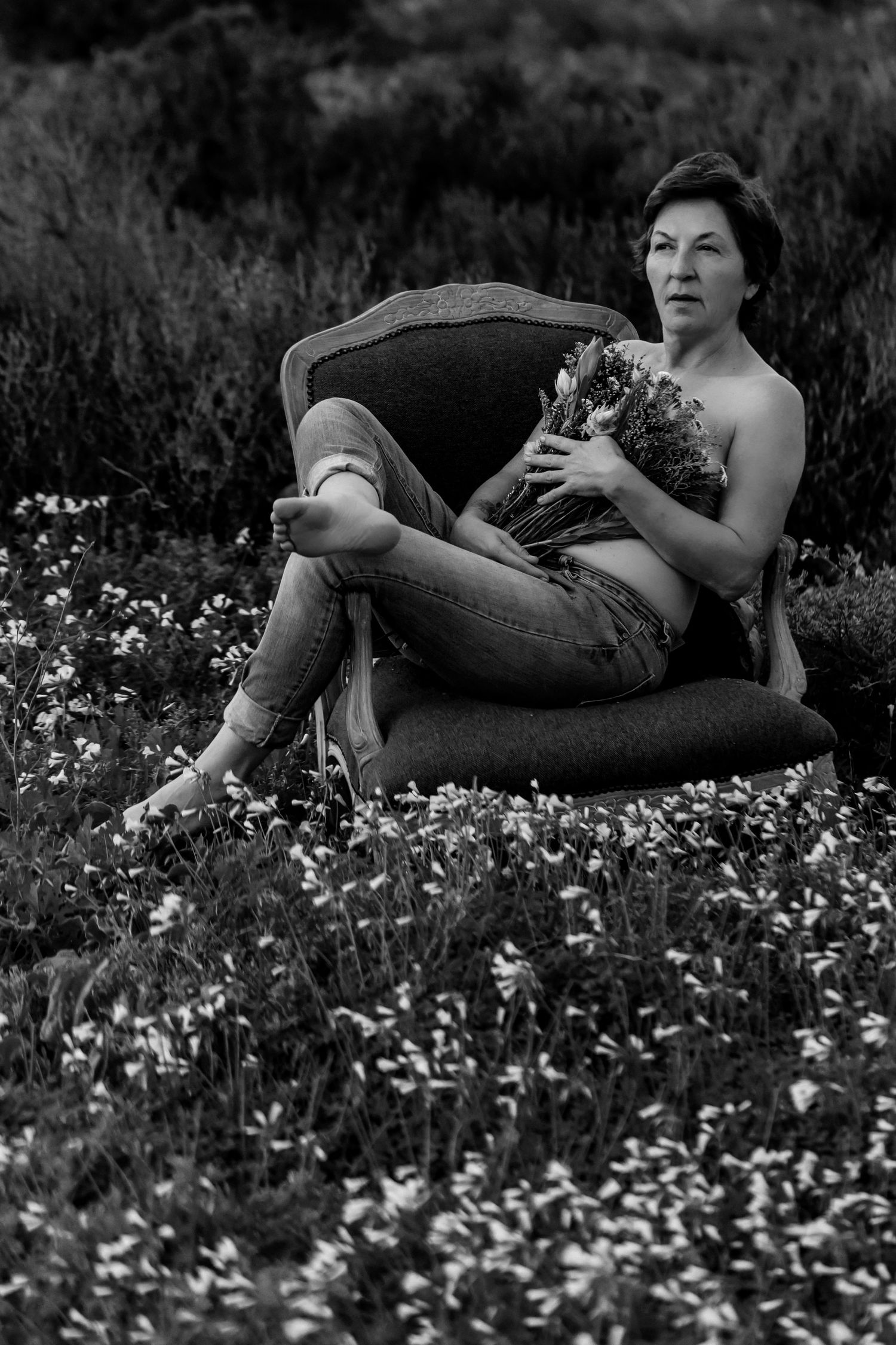 A black and white photo series shows someone reclining in a field of wildflowers on a summer day.