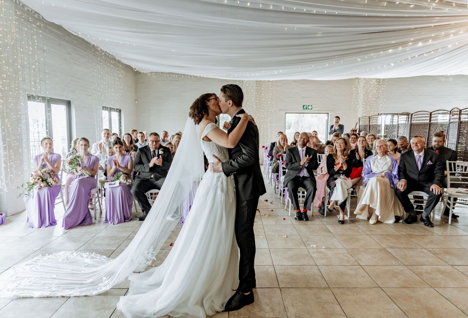 A photo montage of wedding reception scenes showing dancing couples in an elegant white ballroom setting.