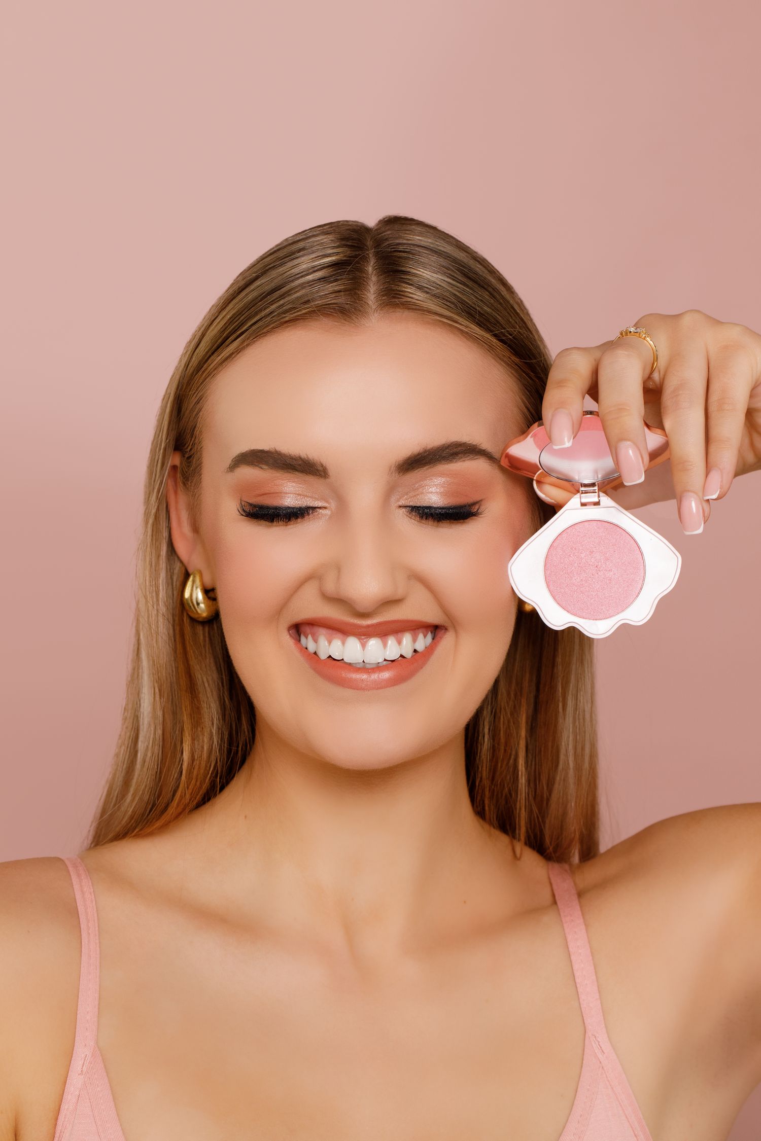 A collage of beauty shots showing bright smiles, glowing skin, and pink tones against a rosy background.