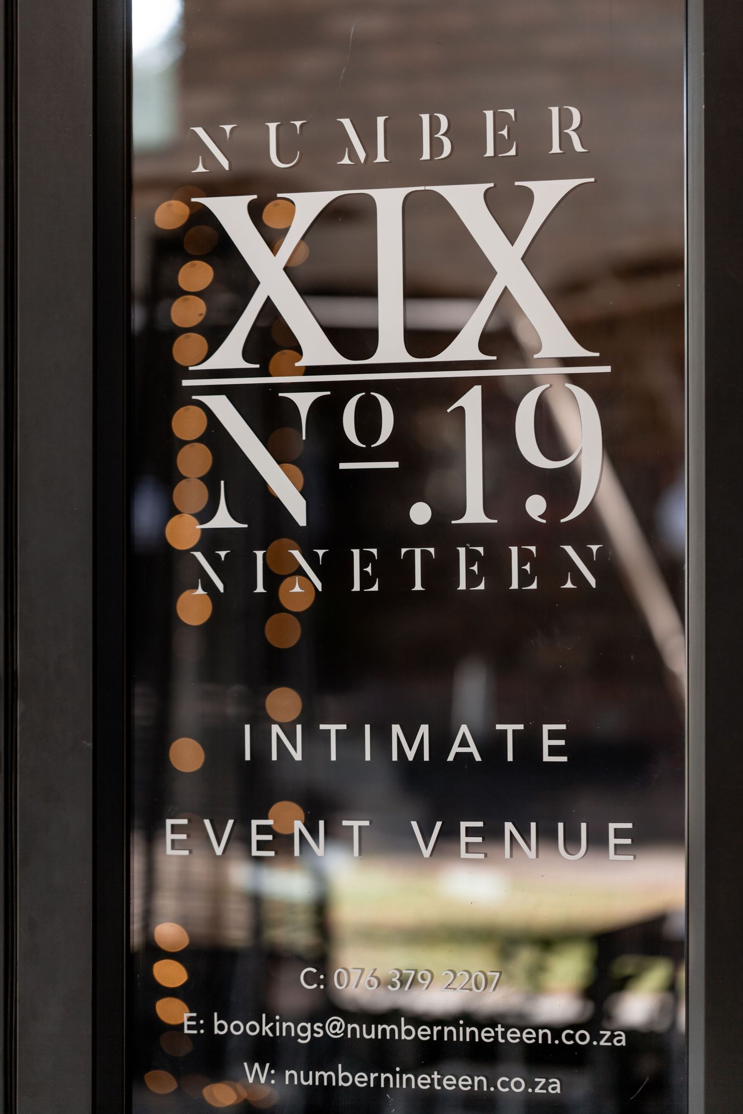 Elegant window signage for Number XIX (No. 19) intimate event venue displaying contact details on frosted glass.