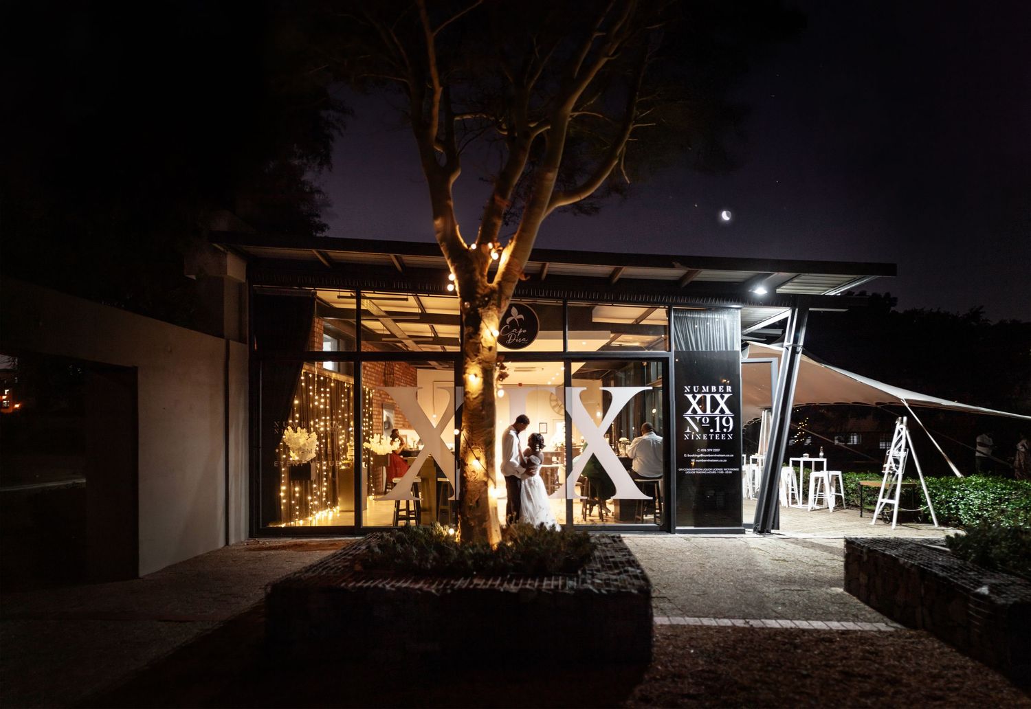 A nighttime side view of glass office buildings with lit windows and illuminated architectural features creates modern ambiance.