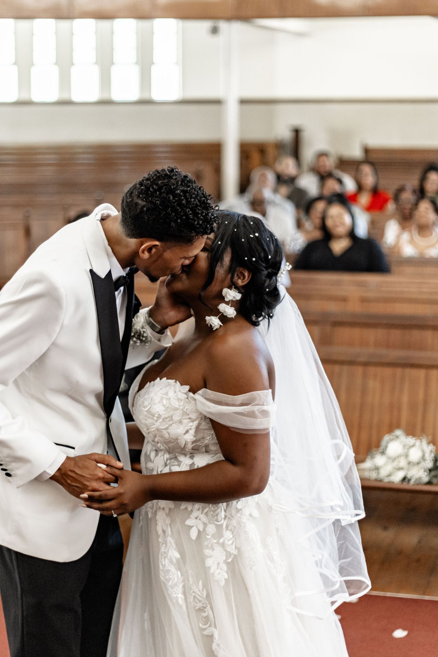 A series of intimate moments between a couple in wedding attire sharing romantic kisses during their ceremony.