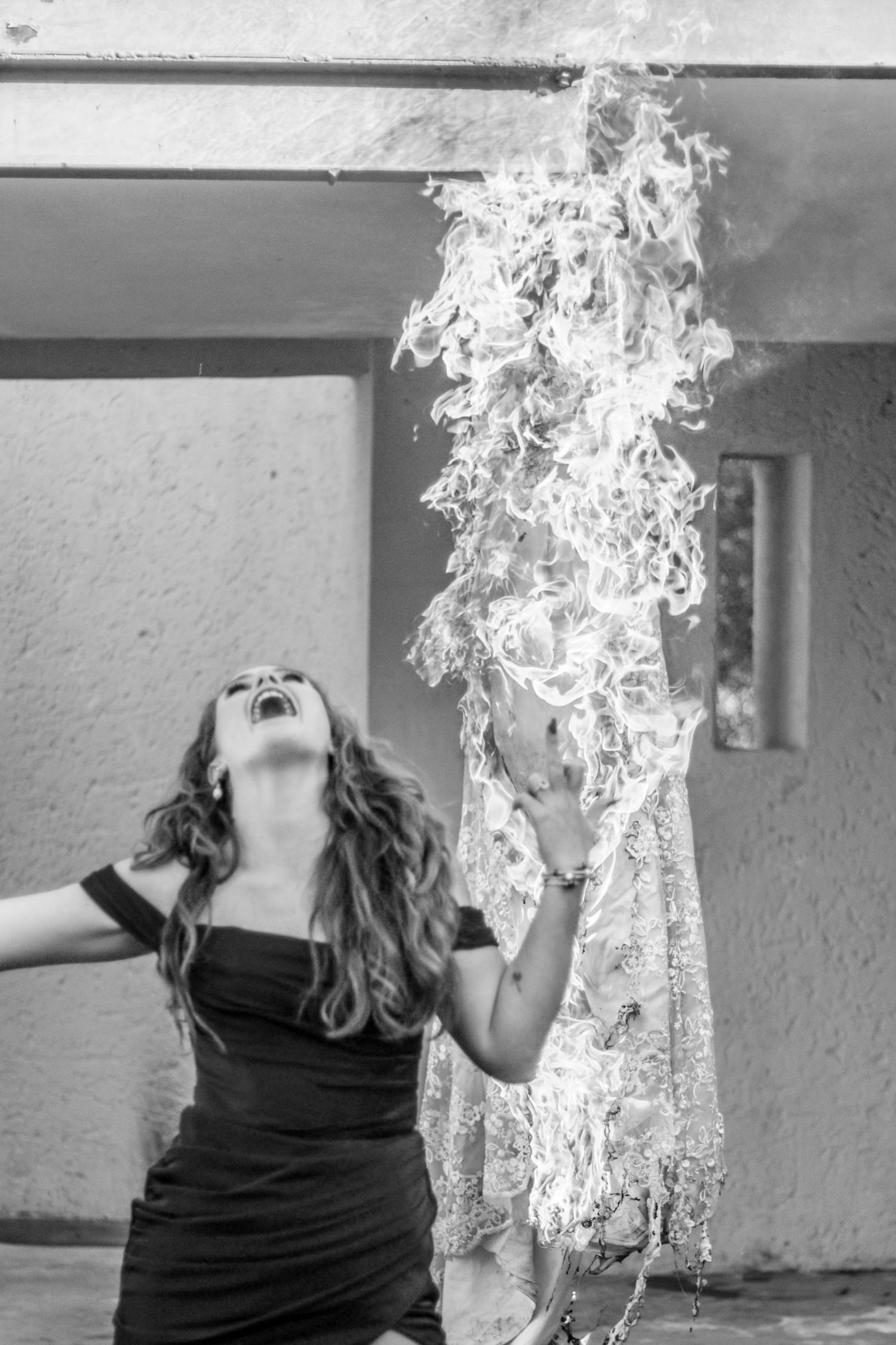 Black and white artistic photo series captures a person exhaling smoke in dramatic poses against a white wall.