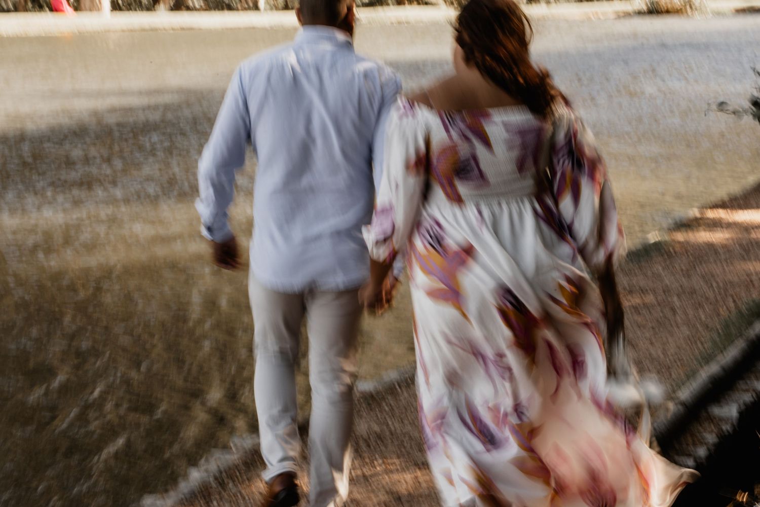 A couple shares an intimate dance moment in a natural outdoor environment.