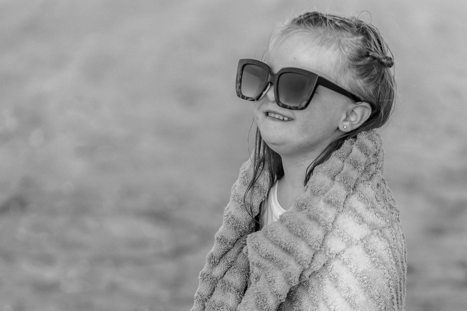A black and white collage of five similar images showing someone wearing sunglasses and a floral dress.