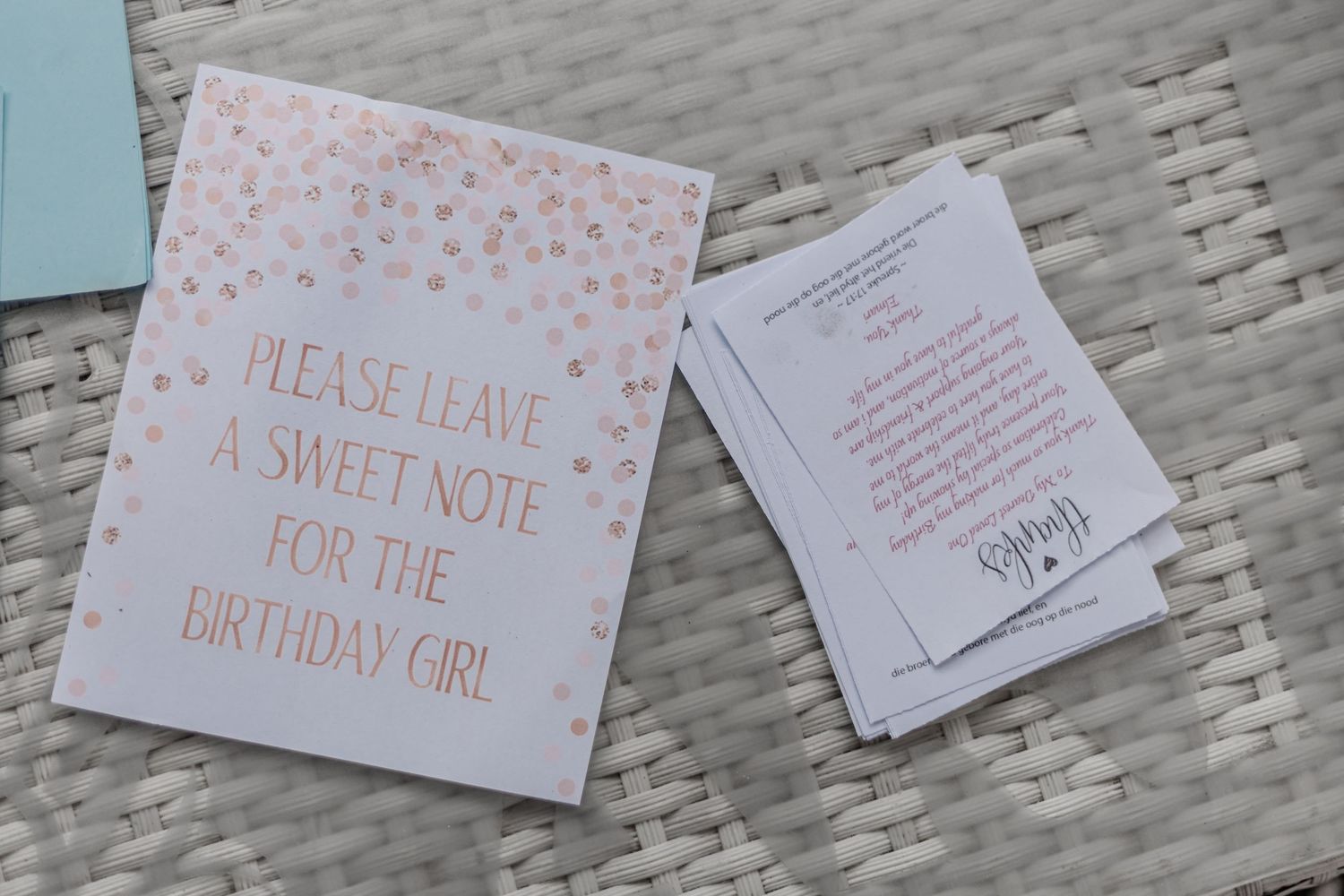 Two pink and white cards displayed on woven surface with text requesting notes for a birthday celebration.