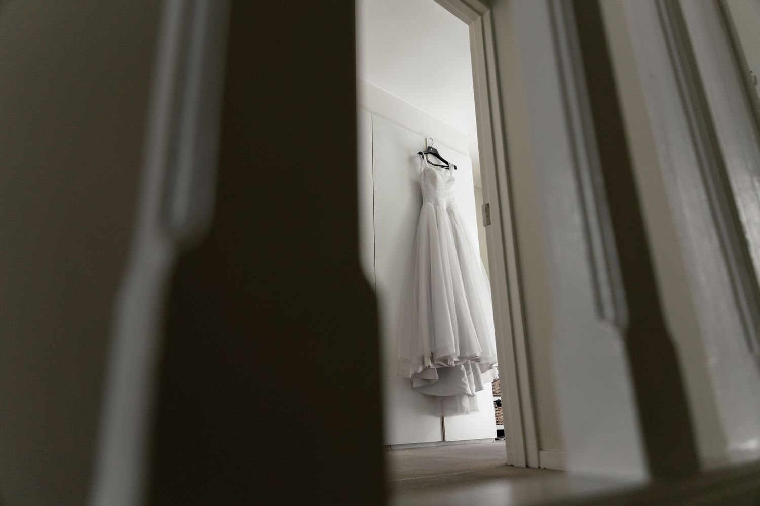 Minimalist interior with sunlight streaming through angled windows casting dramatic shadows on white walls.