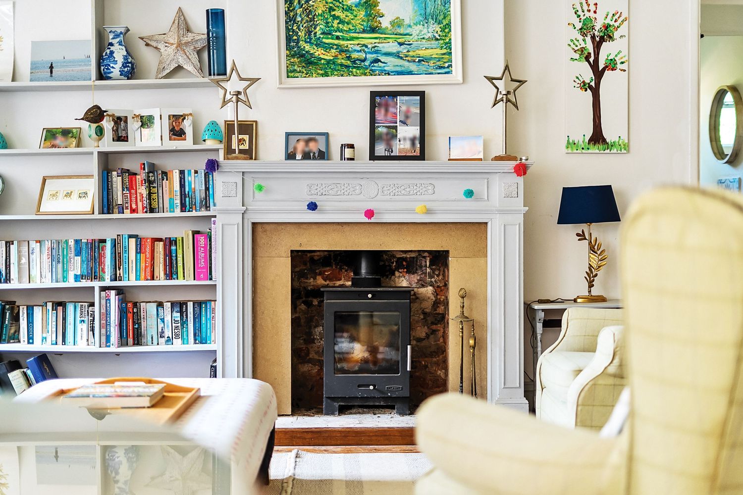 Bright interior room with built-in bookshelves, yellow chairs, and framed artwork on display.