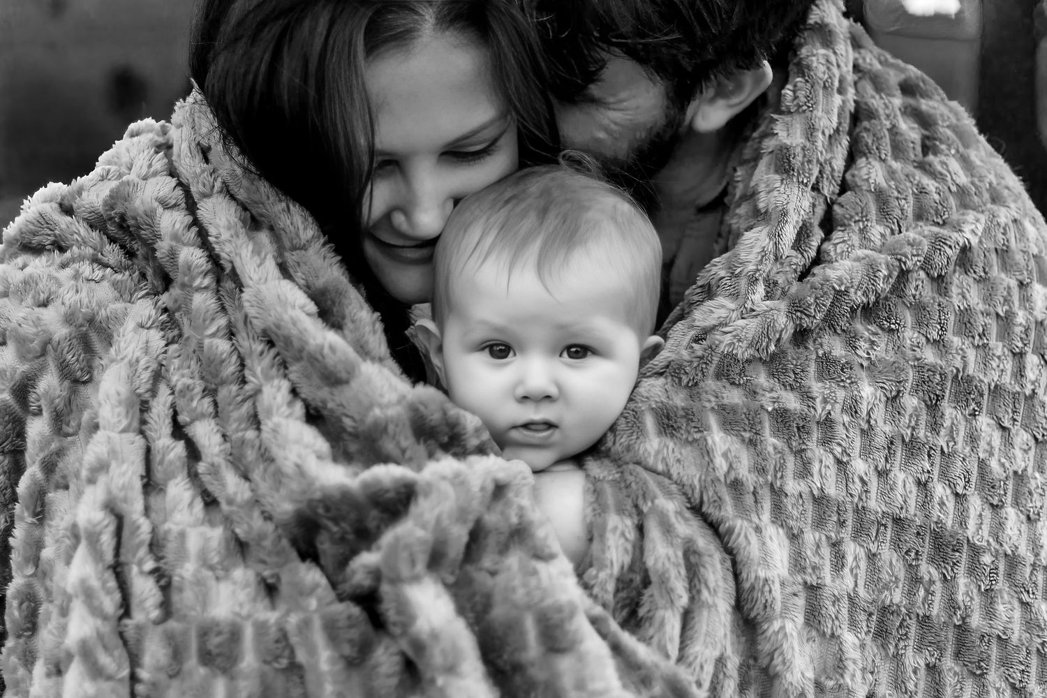 A black and white photo collage shows tender moments between parents and babies in intimate close-up shots.