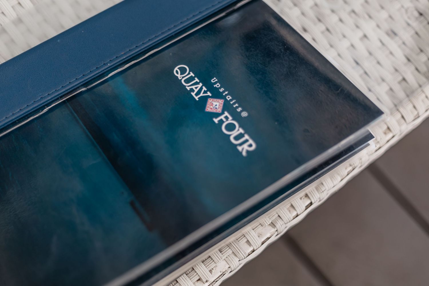 A mobile phone displaying the Snapchat logo on its screen rests on a white textured surface.