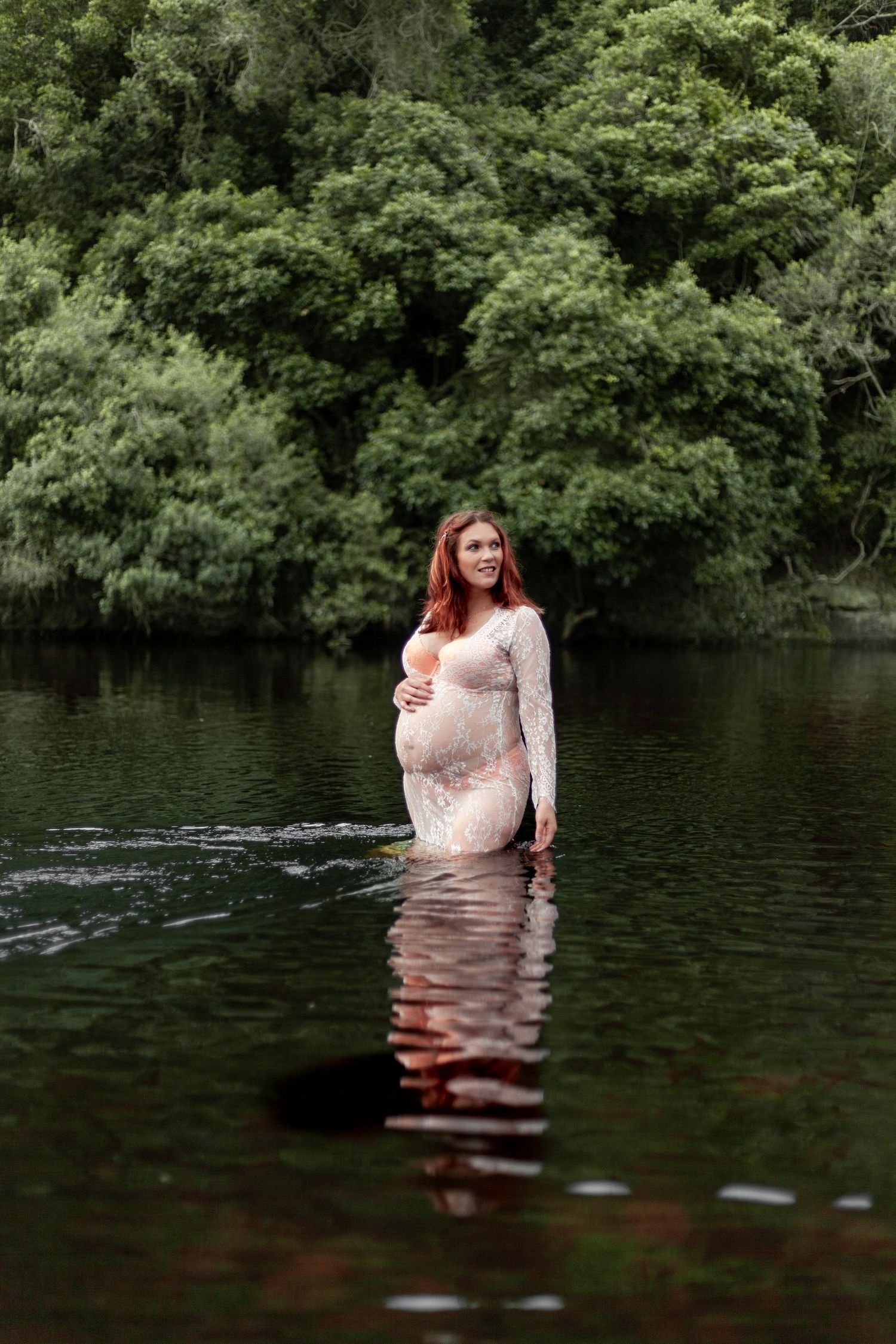 Sequential photos show someone in a white dress wading deeper into a dark wooded lake or pond with trees in background.
