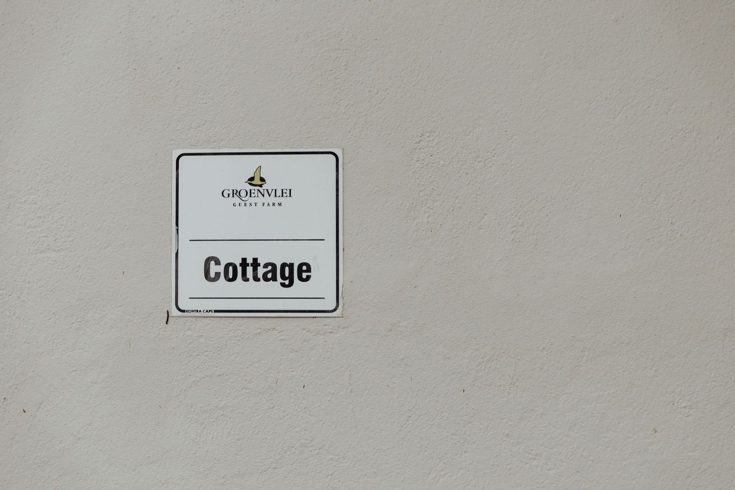 A simple white wall-mounted sign with 