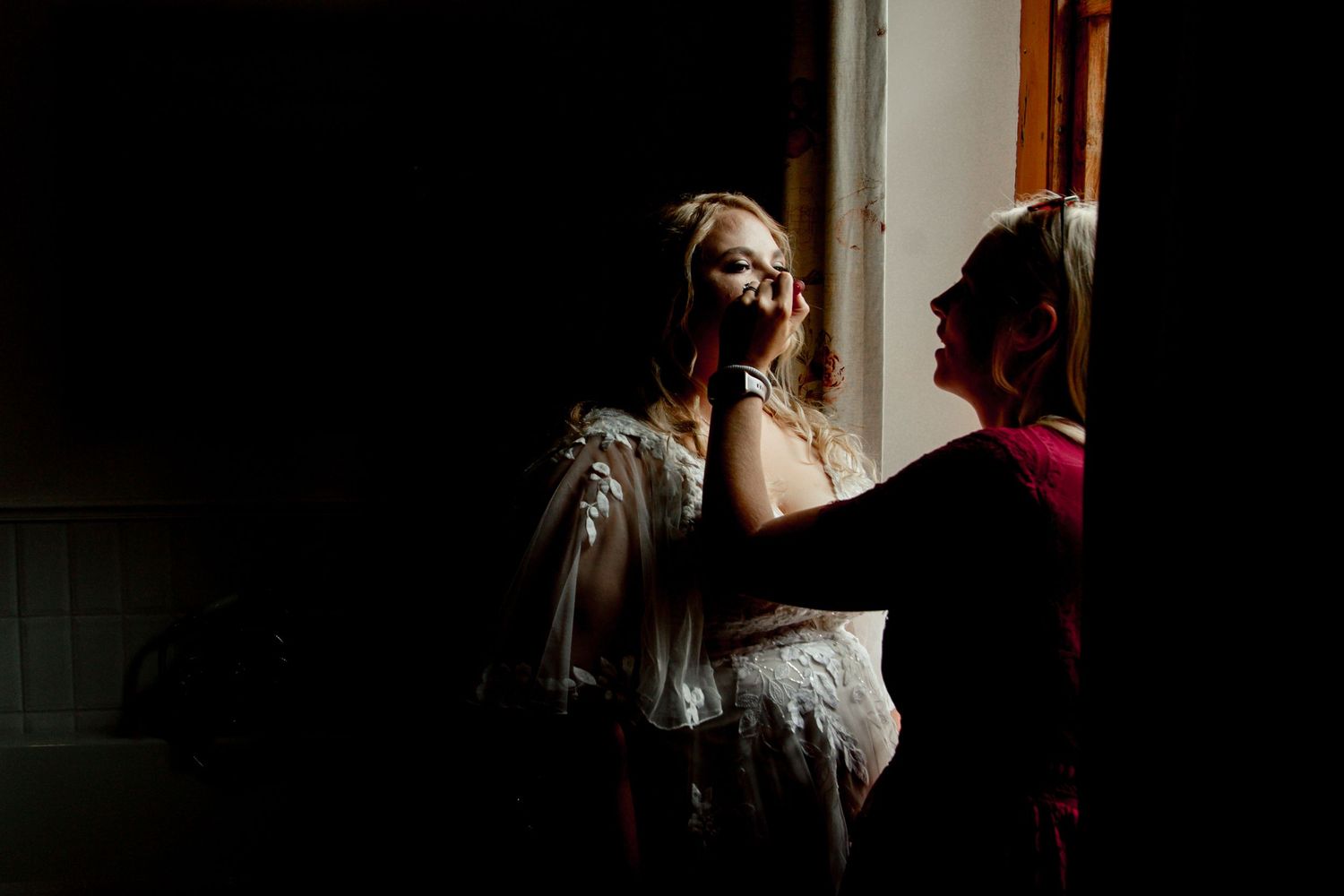 Wedding couple shares an intimate dance in a dimly lit room during their reception celebration.