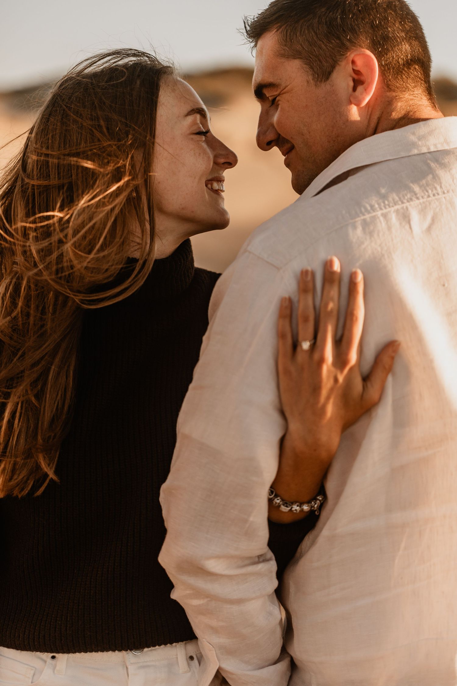A romantic couple embraces during sunset, sharing intimate moments in a series of candid photographs.