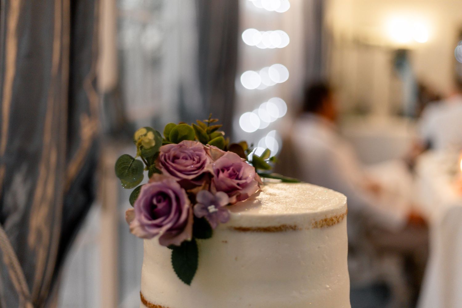 Close-up details of wedding cakes decorated with dusty purple roses and delicate floral arrangements.