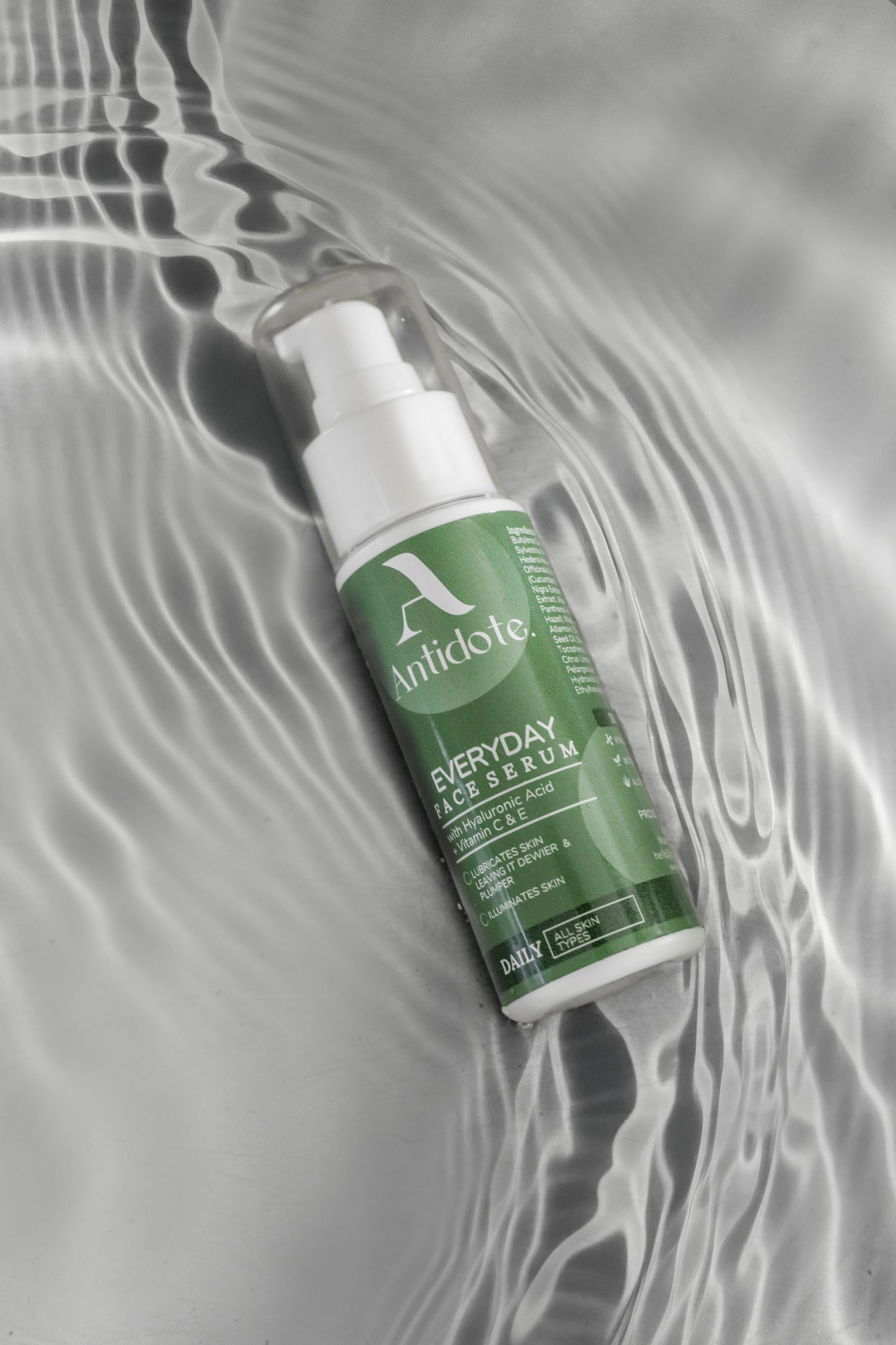 A green and white bottle of Pure Ratio CBD cream floats in rippling water with a minimalist aesthetic.