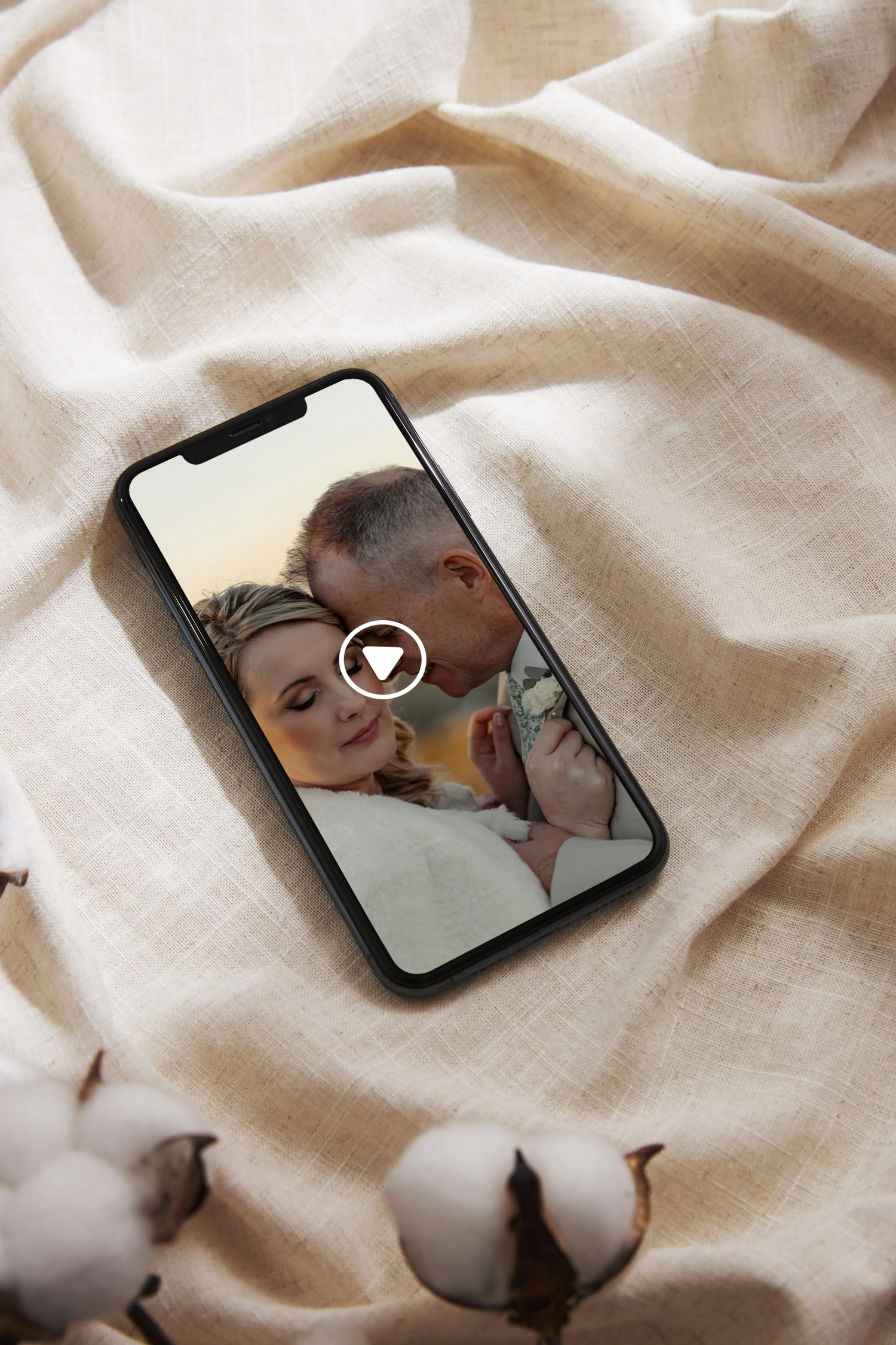 Close-up composition of cotton balls on beige linen fabric with mobile phone screens reflected against textured background.