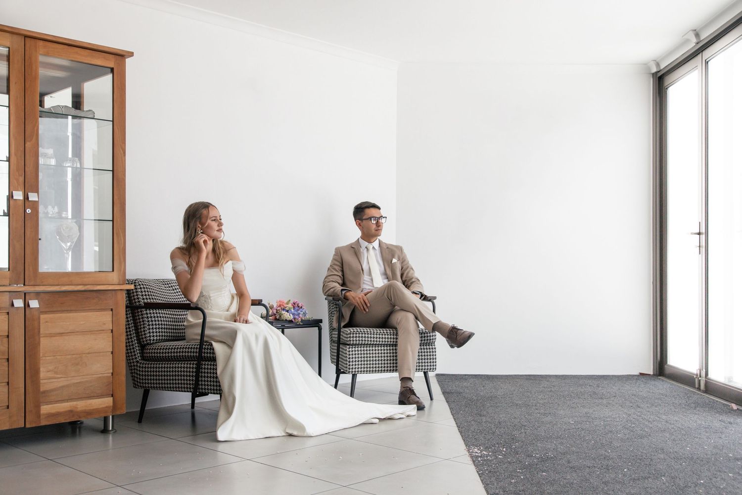 A wedding photo series showing intimate moments between couples in an elegant white interior space with wooden accents.
