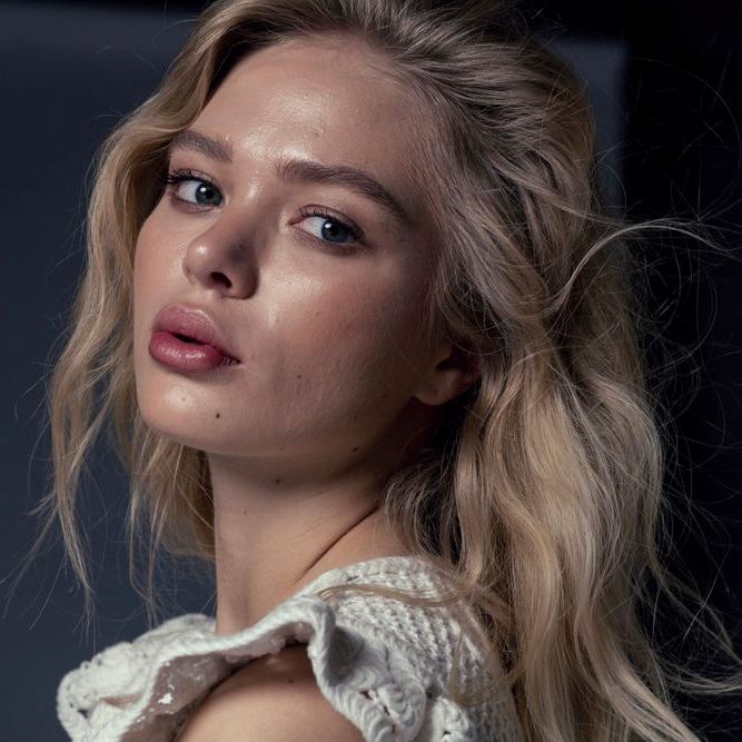 Beauty portrait featuring wavy blonde hair and vintage-style white lace top.