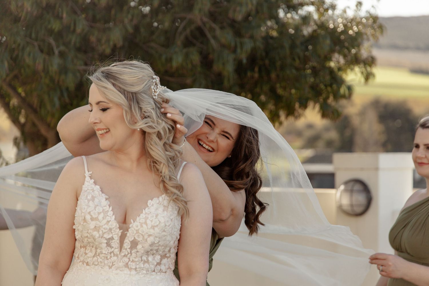 Two joyful people share a candid moment together during an outdoor wedding ceremony.