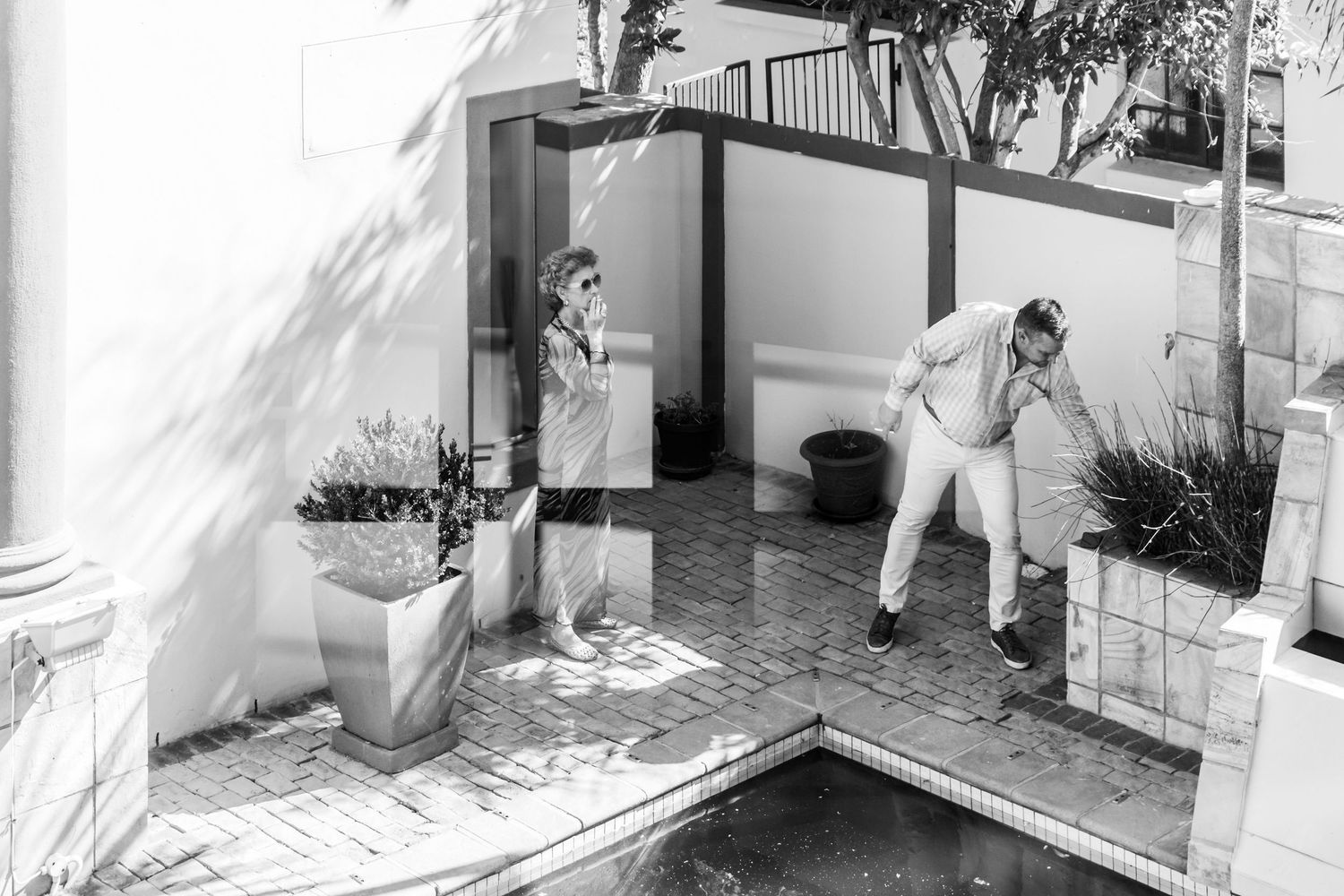 A series of black and white photographs showing a wedding dress and preparations in an elegant interior setting.